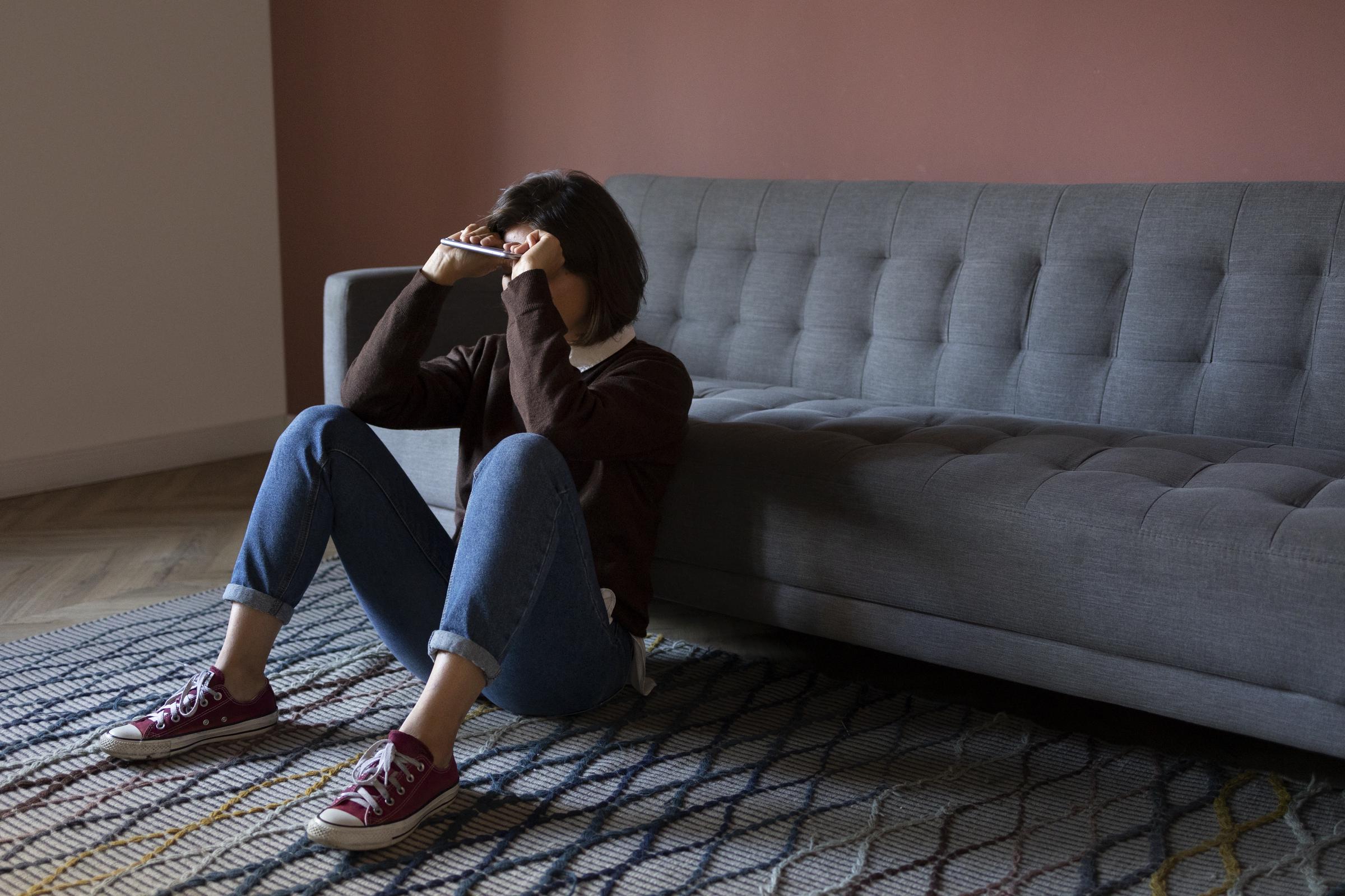 A shattered woman sitting on the floor | Source: Freepik