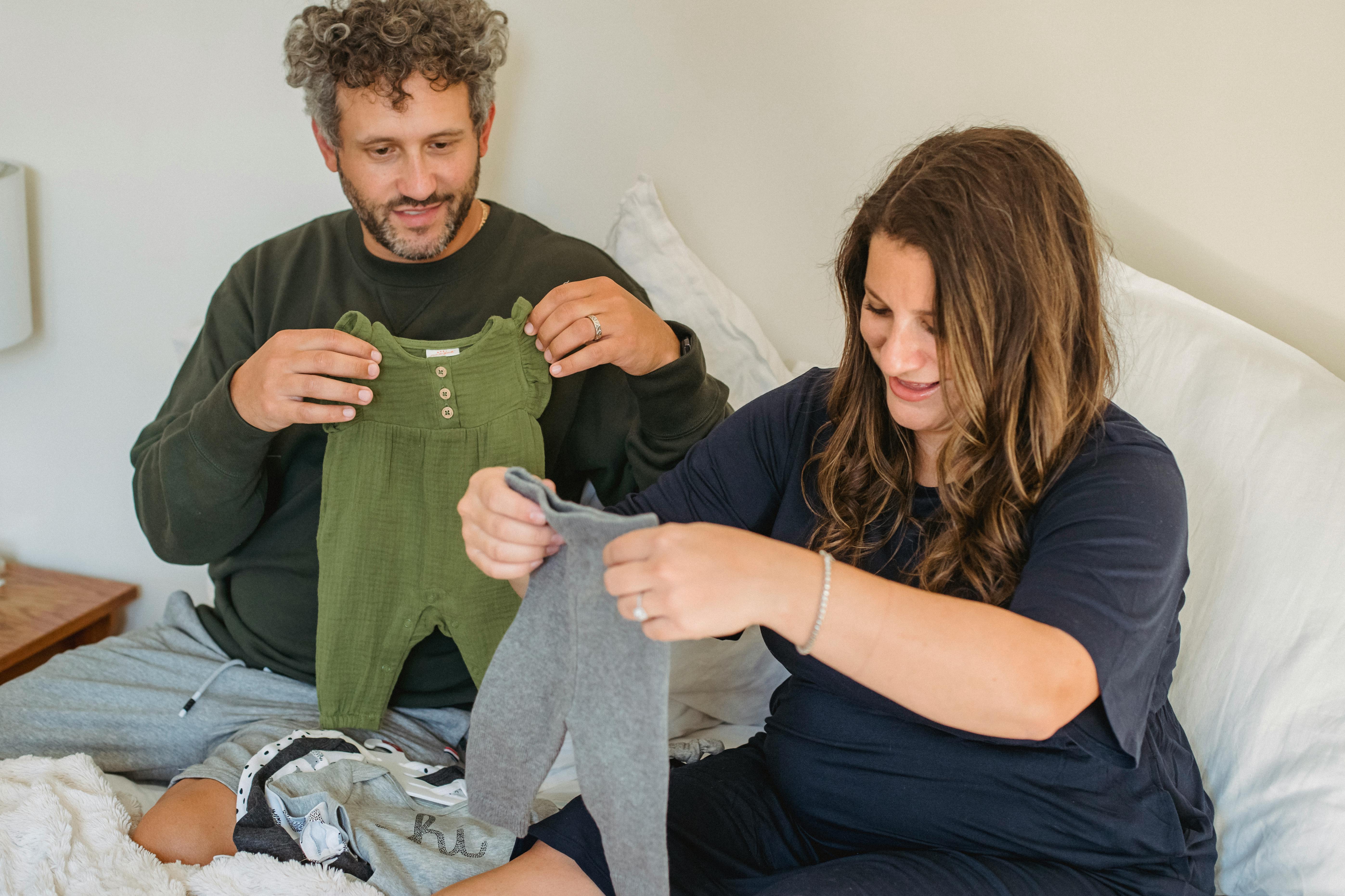 A couple watching baby clothes | Source: Pexels