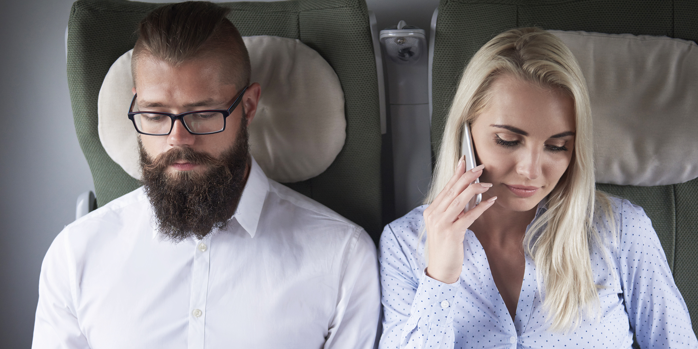 Two people seated on a plane | Source: Shutterstock