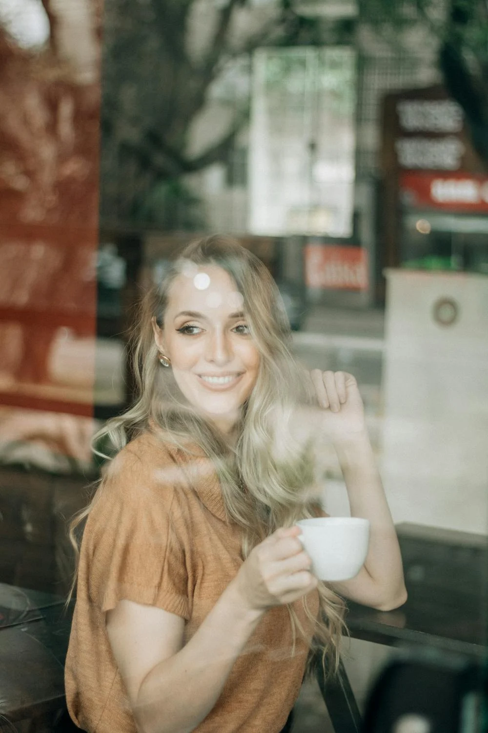 A smiling woman drinking coffee | Source: Pexels