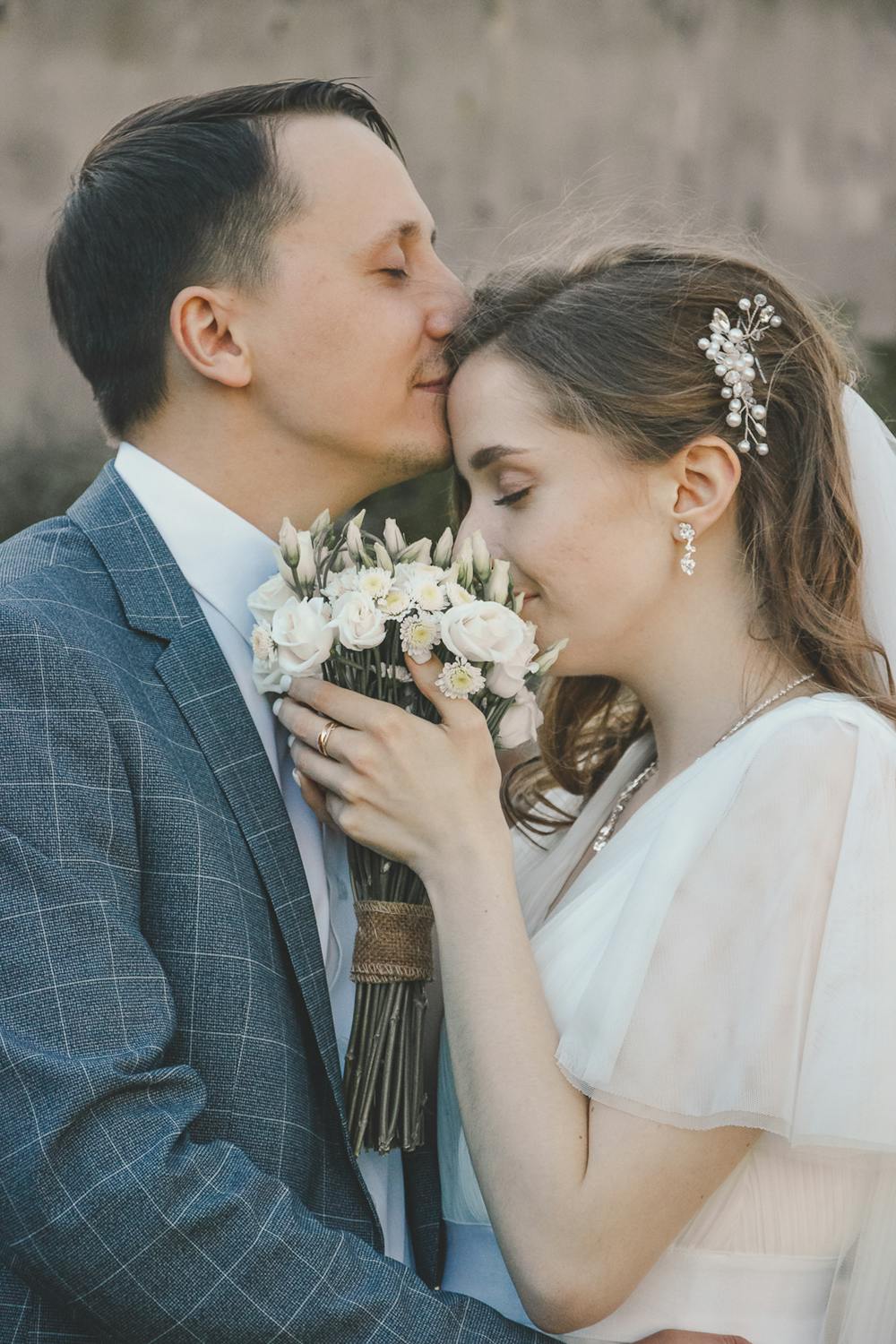 A groom kissing his bride's forehead | Source: Pexels