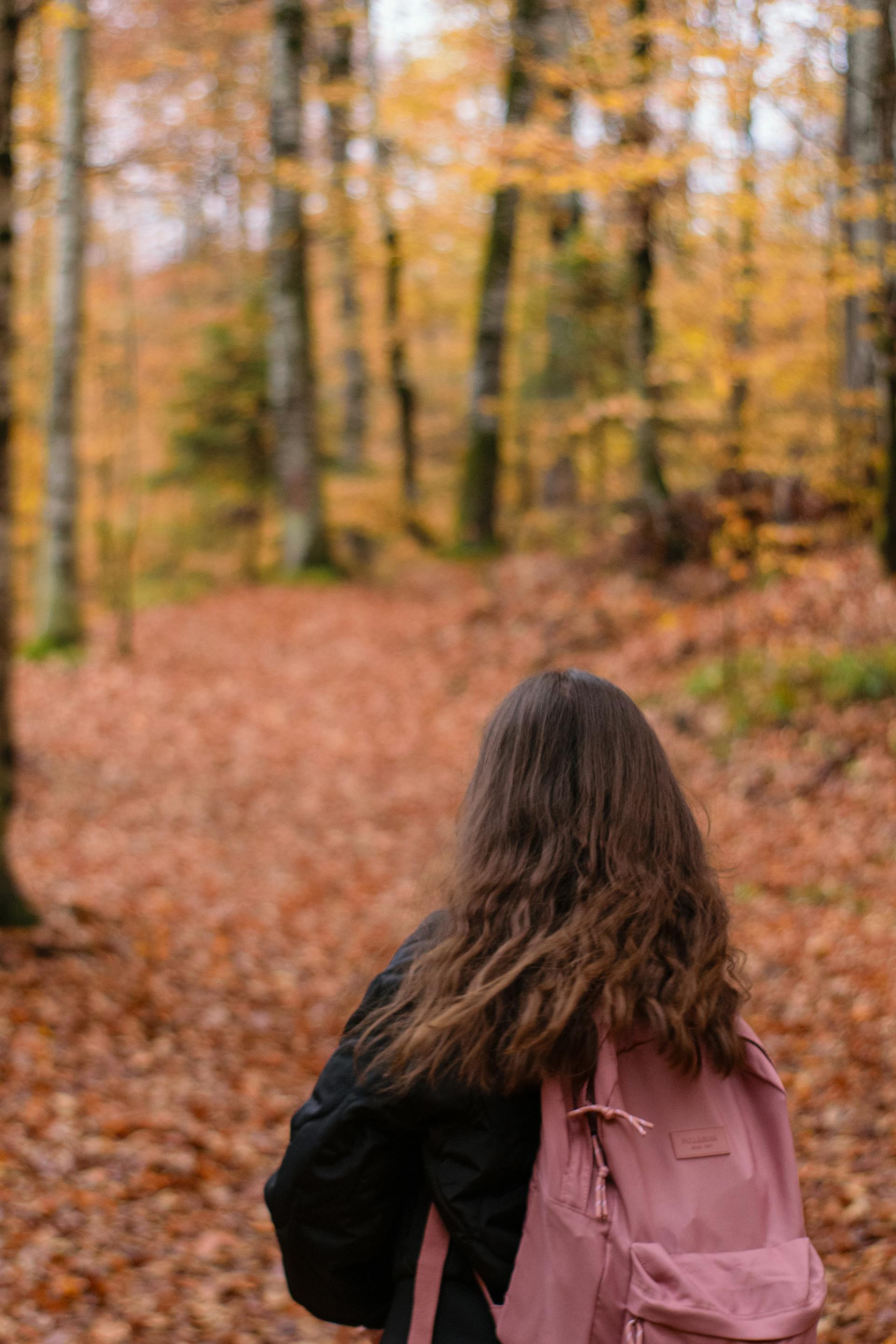 A woman standing in a park during the autumn season | Source: Pexels