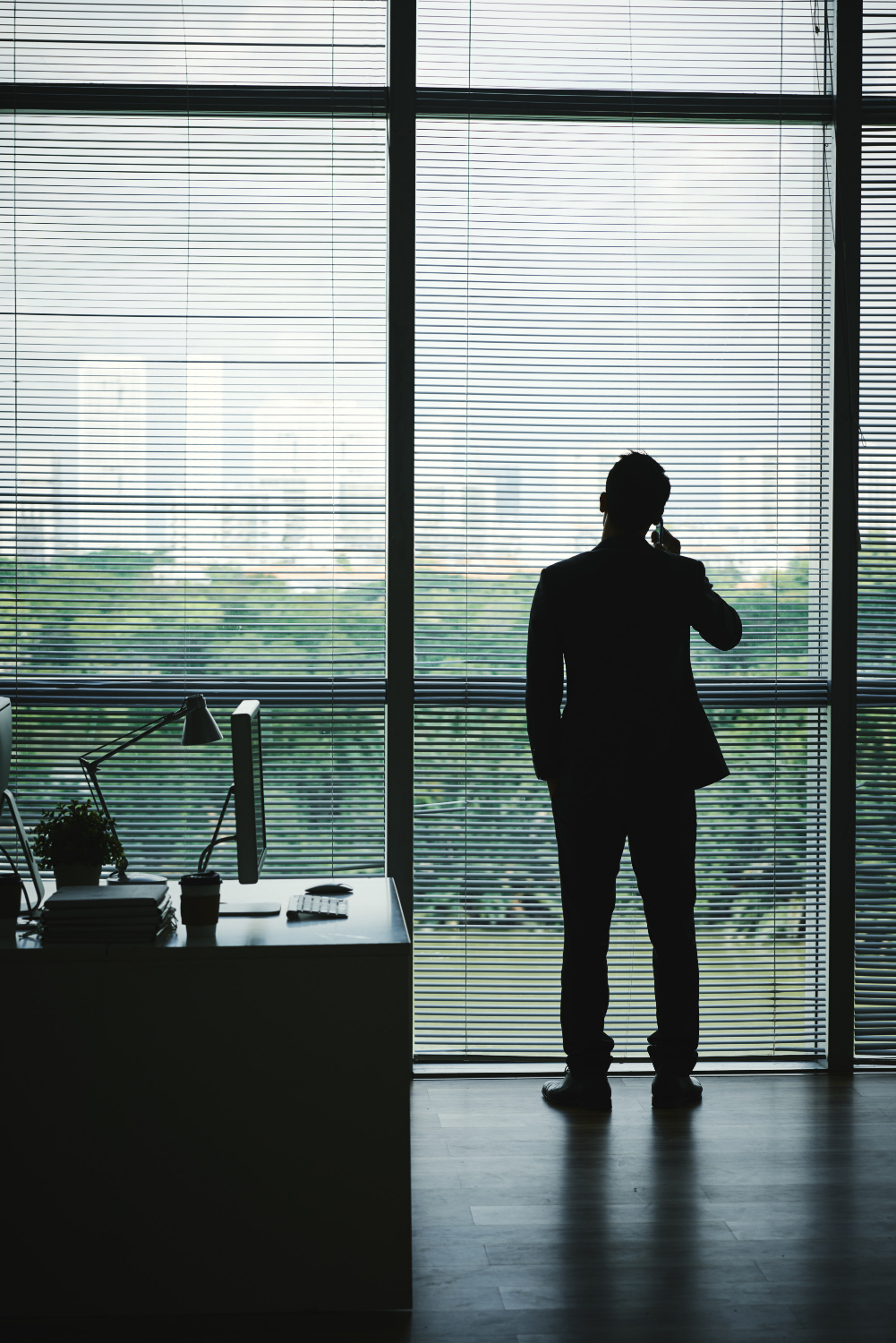 Silhouette of a man talking on the phone in his office | Source: Freepik