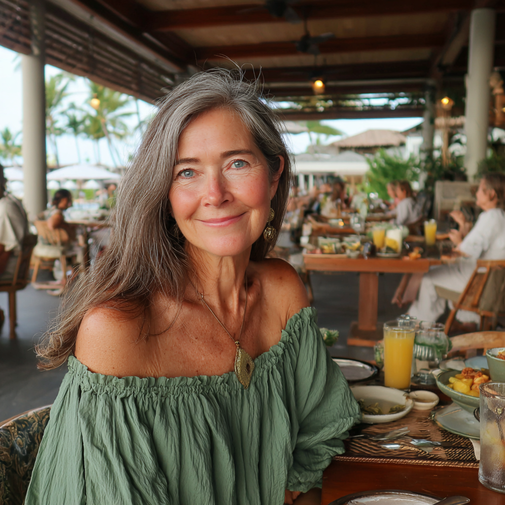 A smiling older woman sitting at a table | Source: Midjourney