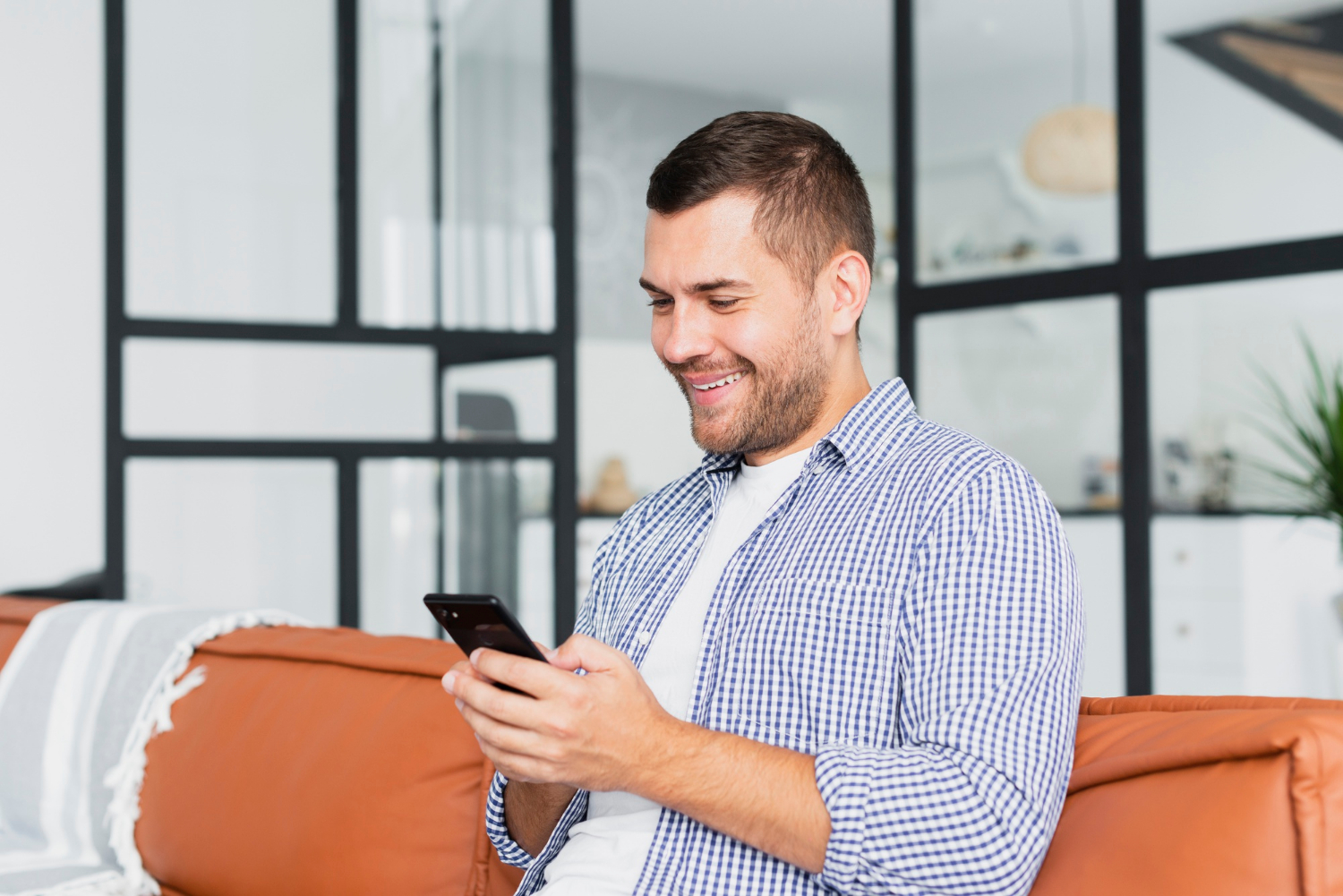 A man looking at his phone and smiling | Source: Freepik