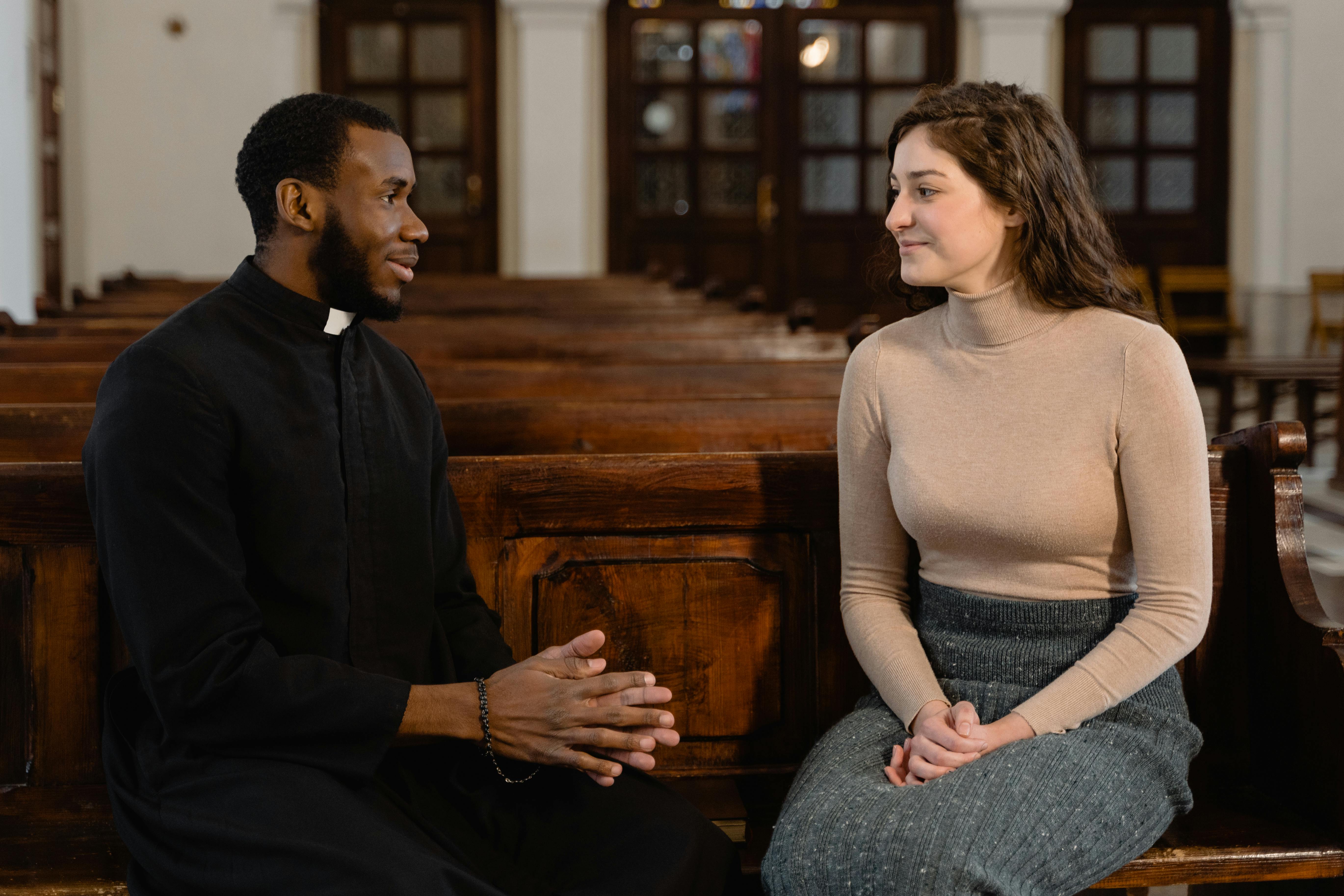 A young woman talking to a priest | Source: Pexels