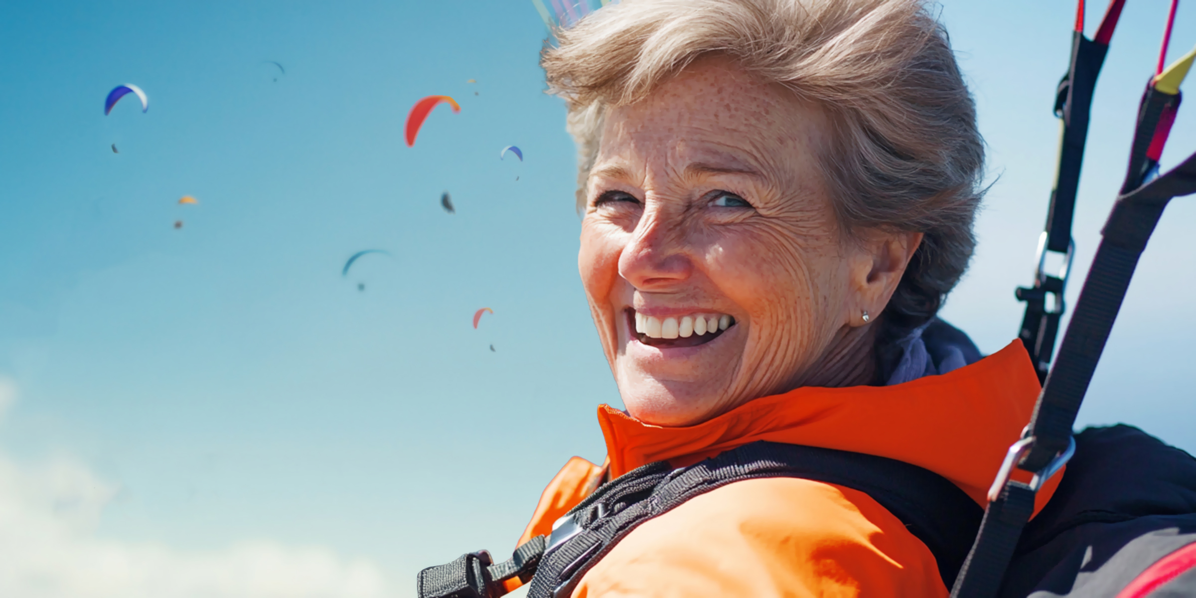 Happy elderly woman paragliding | Source: Midjourney