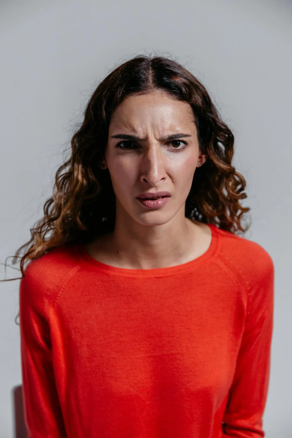 An angry woman in a red sweater ⏐ Source: Pexels