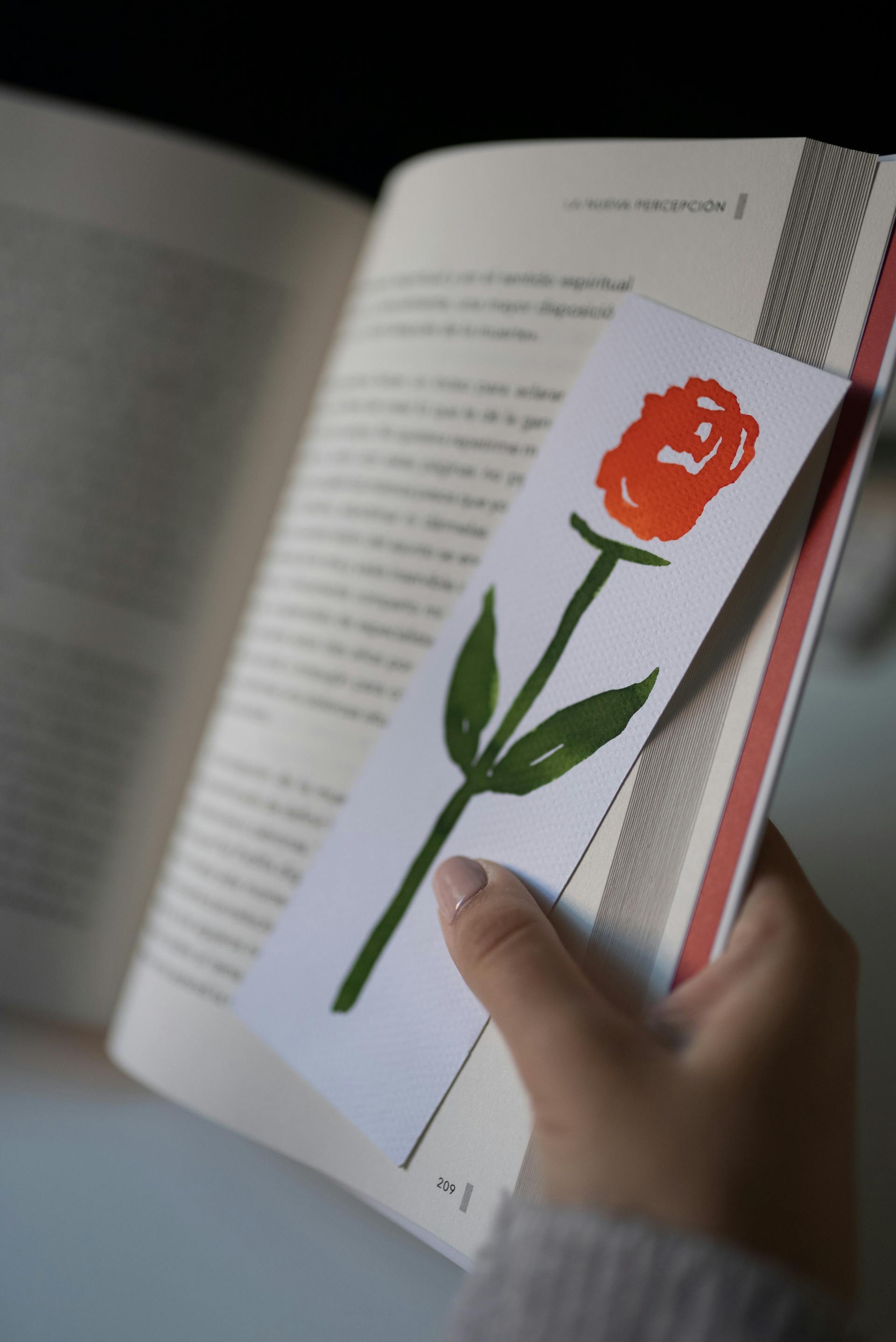 A person holding a book and a bookmark | Source: Pexels