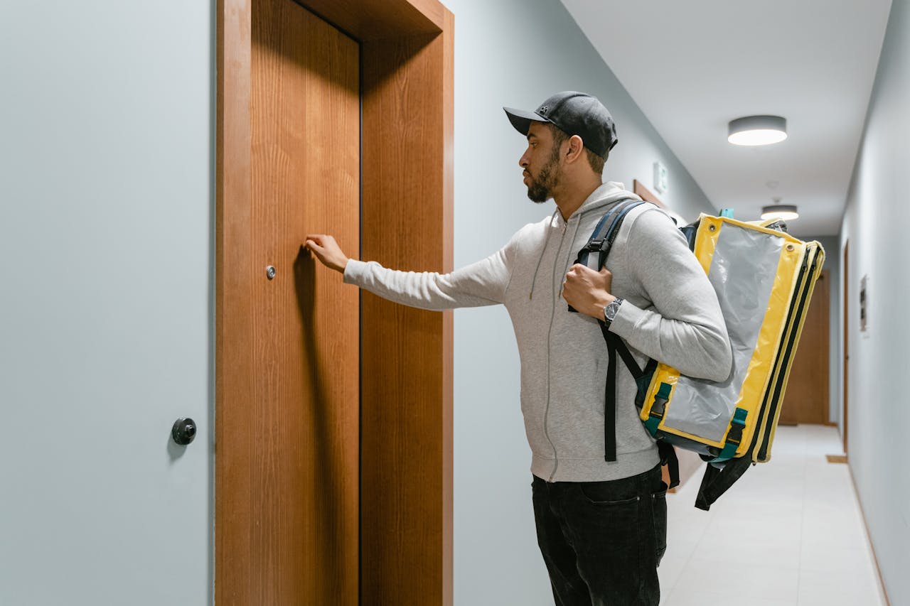 A deliveryman knocking on a hotel room door | Source: Pexels