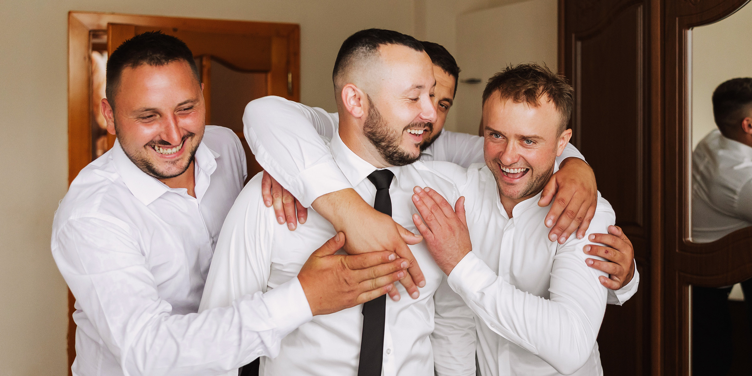 A groom laughing with his groomsmen | Source: Shutterstock