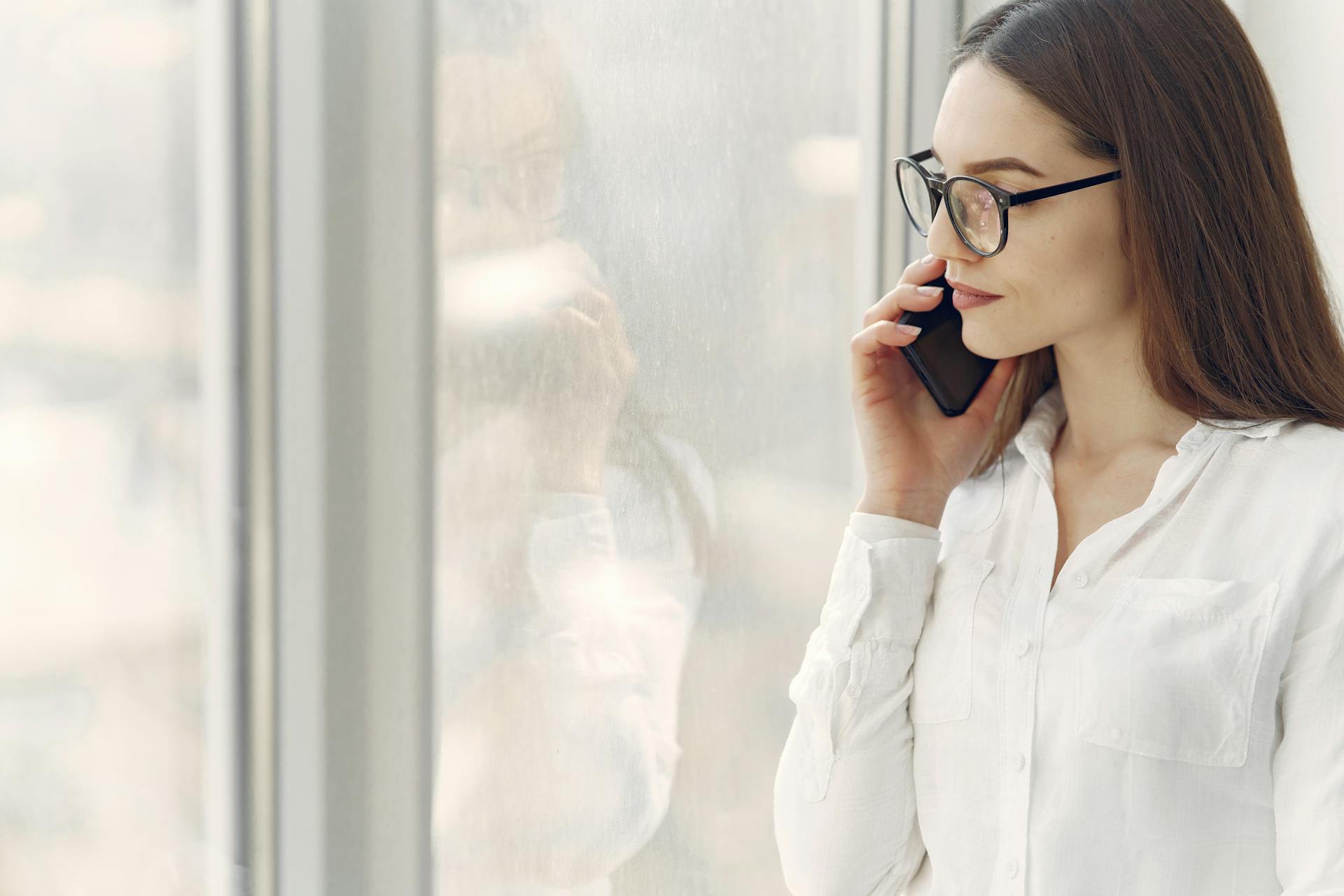 A woman smiling grimly during a phone call | Source: Pexels