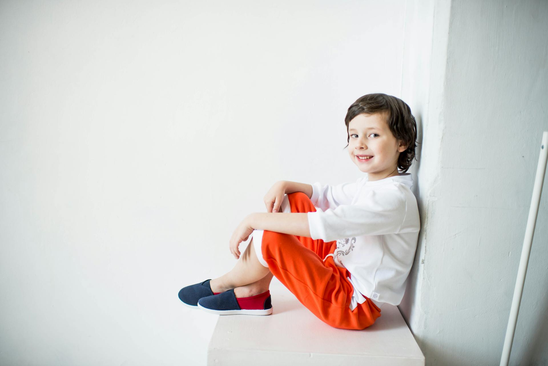 A young boy leaning against a wall | Source: Pexels