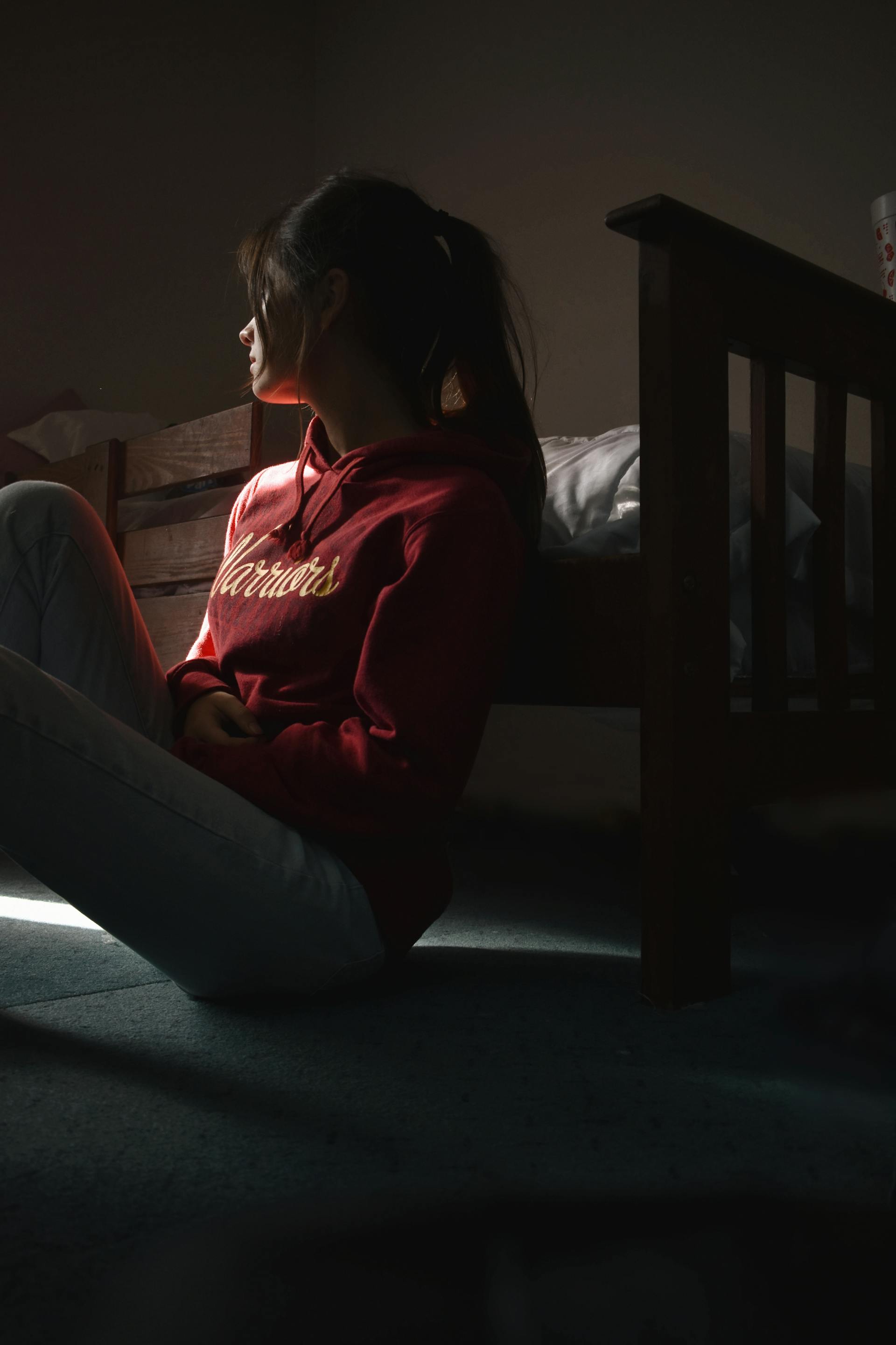 A young woman sitting on the floor in her room | Source: Pexels