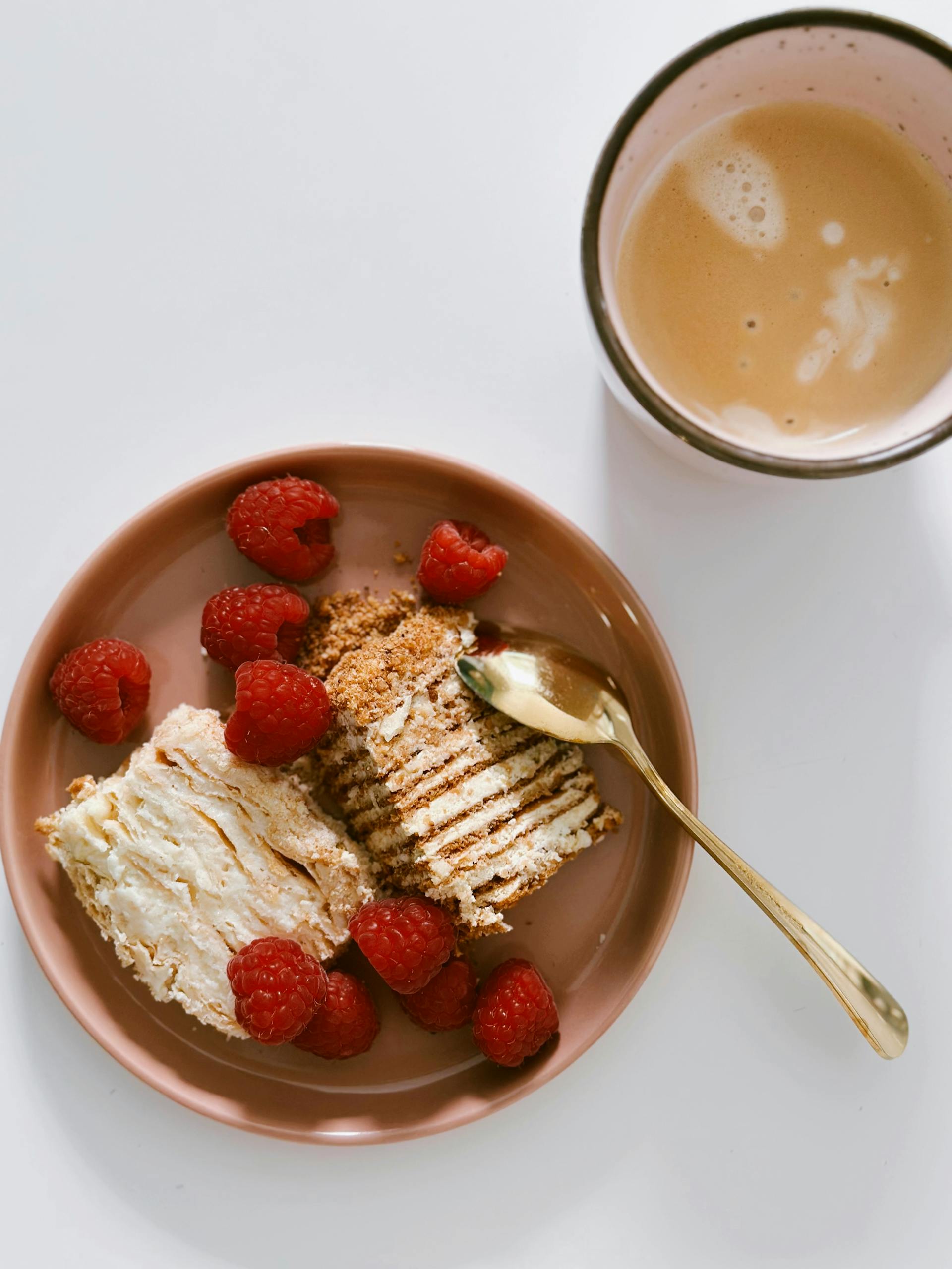 A dessert and coffee cup lying on a white surface | Source: Pexels