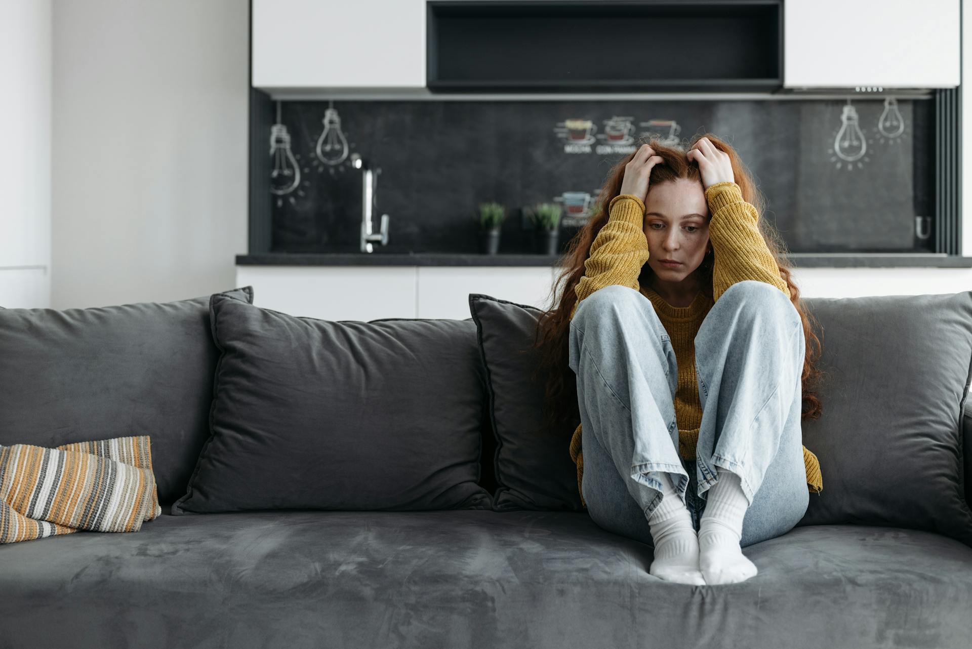 A depressed woman sitting on a couch | Source: Pexels