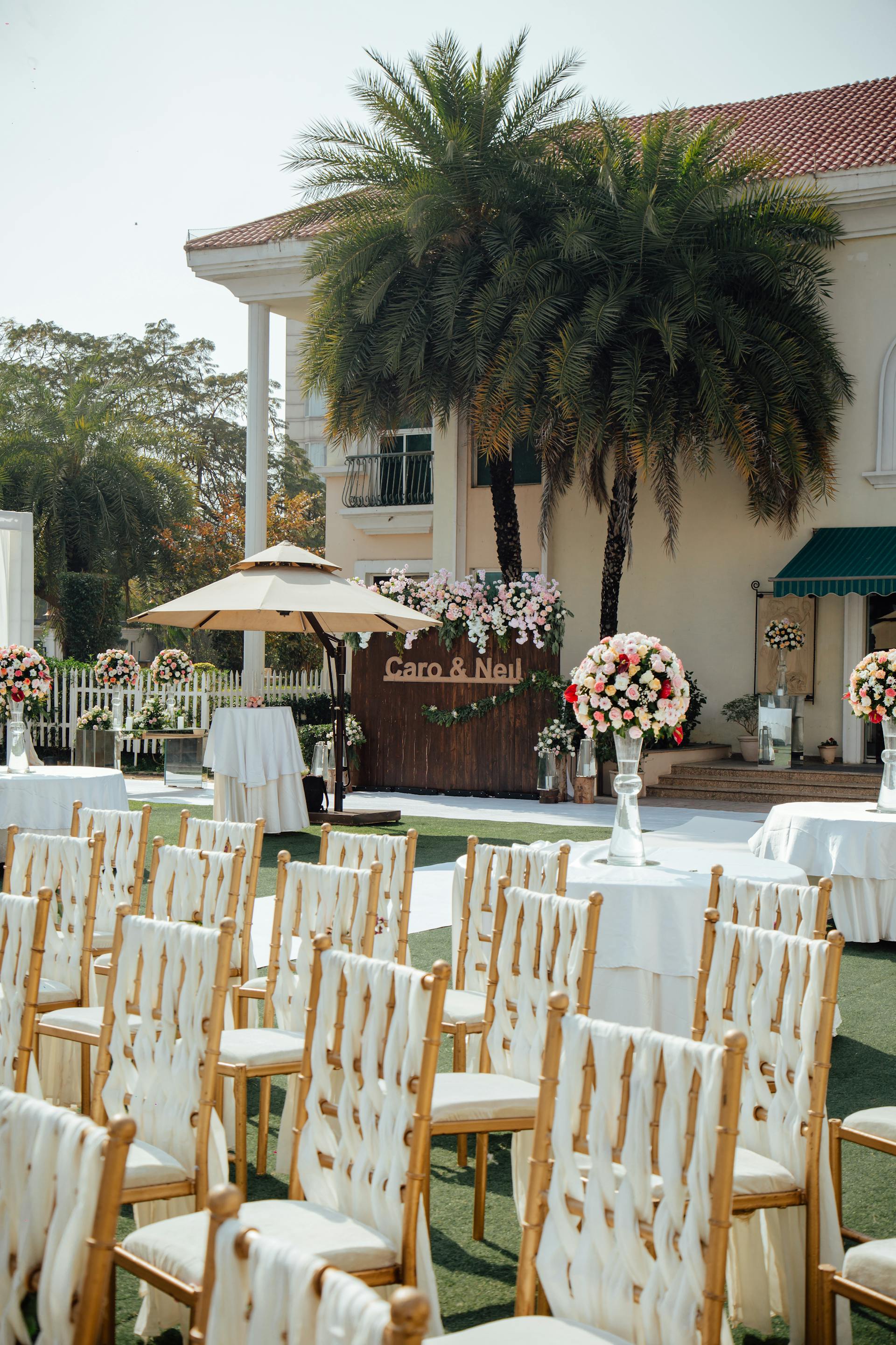 A backyard wedding with chairs, flowers, and tables arranged | Source: Pexels