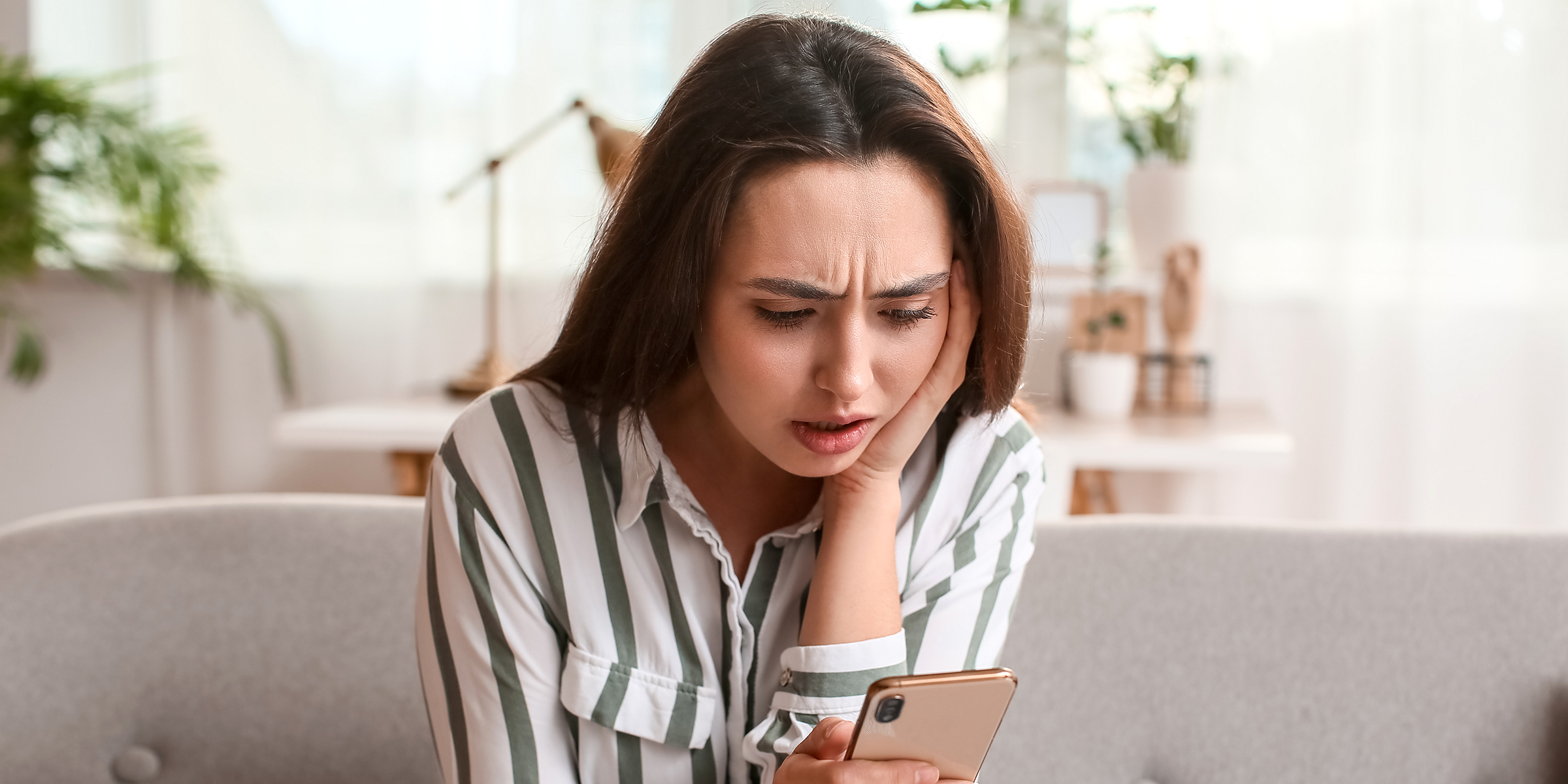 A shocked woman reading a text on her phone | Source: Shutterstock