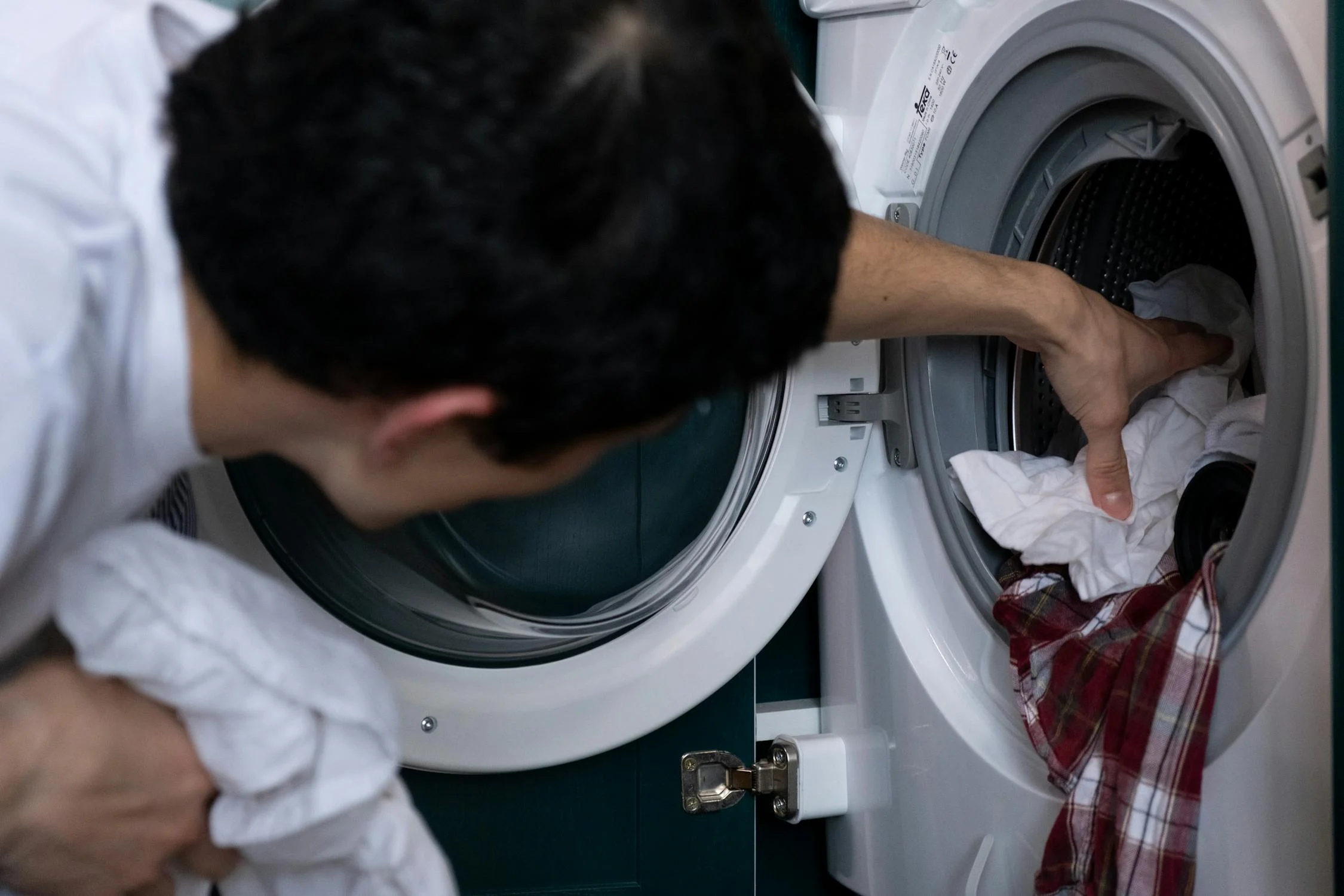 A man loading the washing machine | Source: Pexels