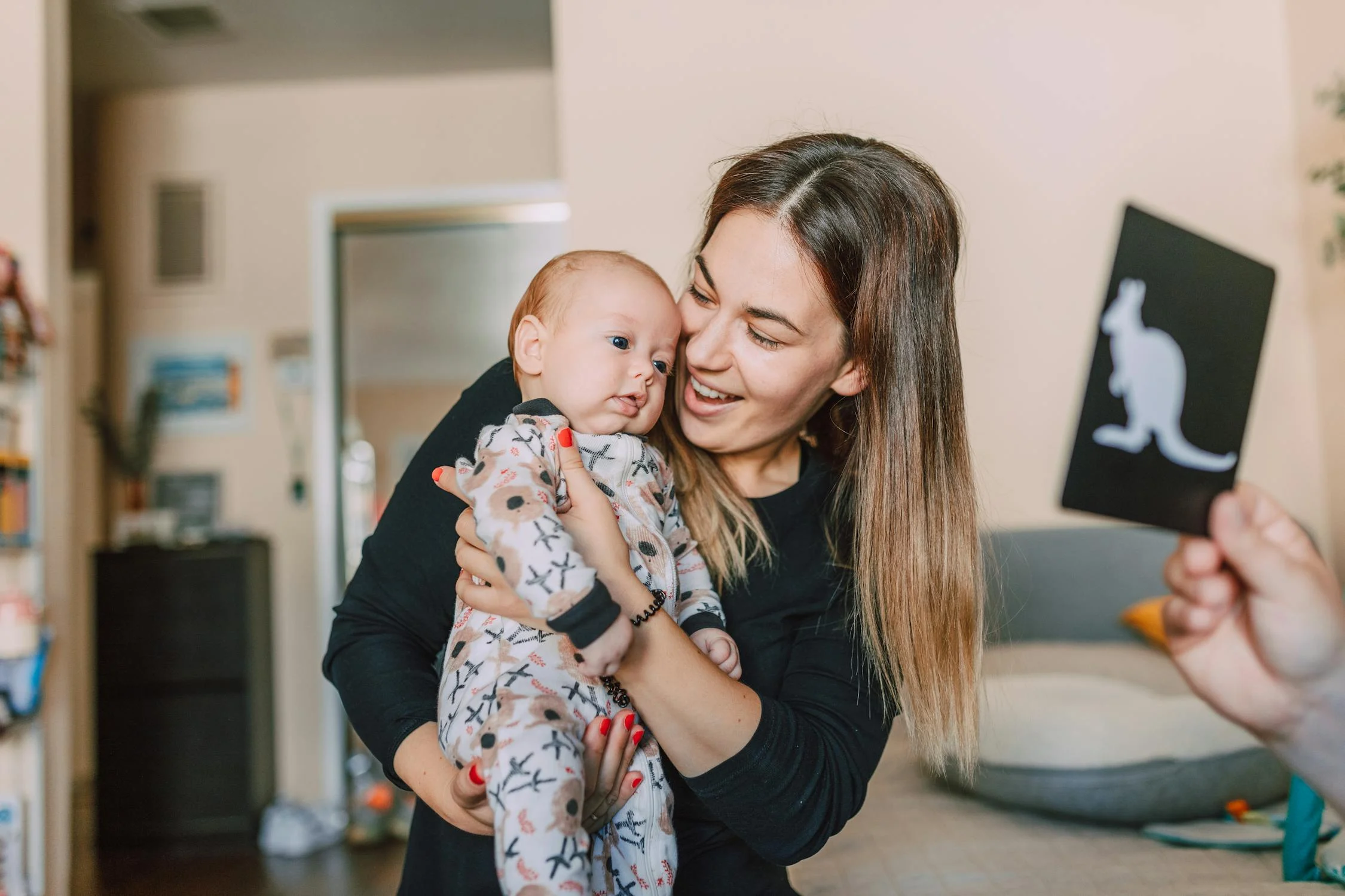 A woman holding a kid in the nursery | Source: Pexels