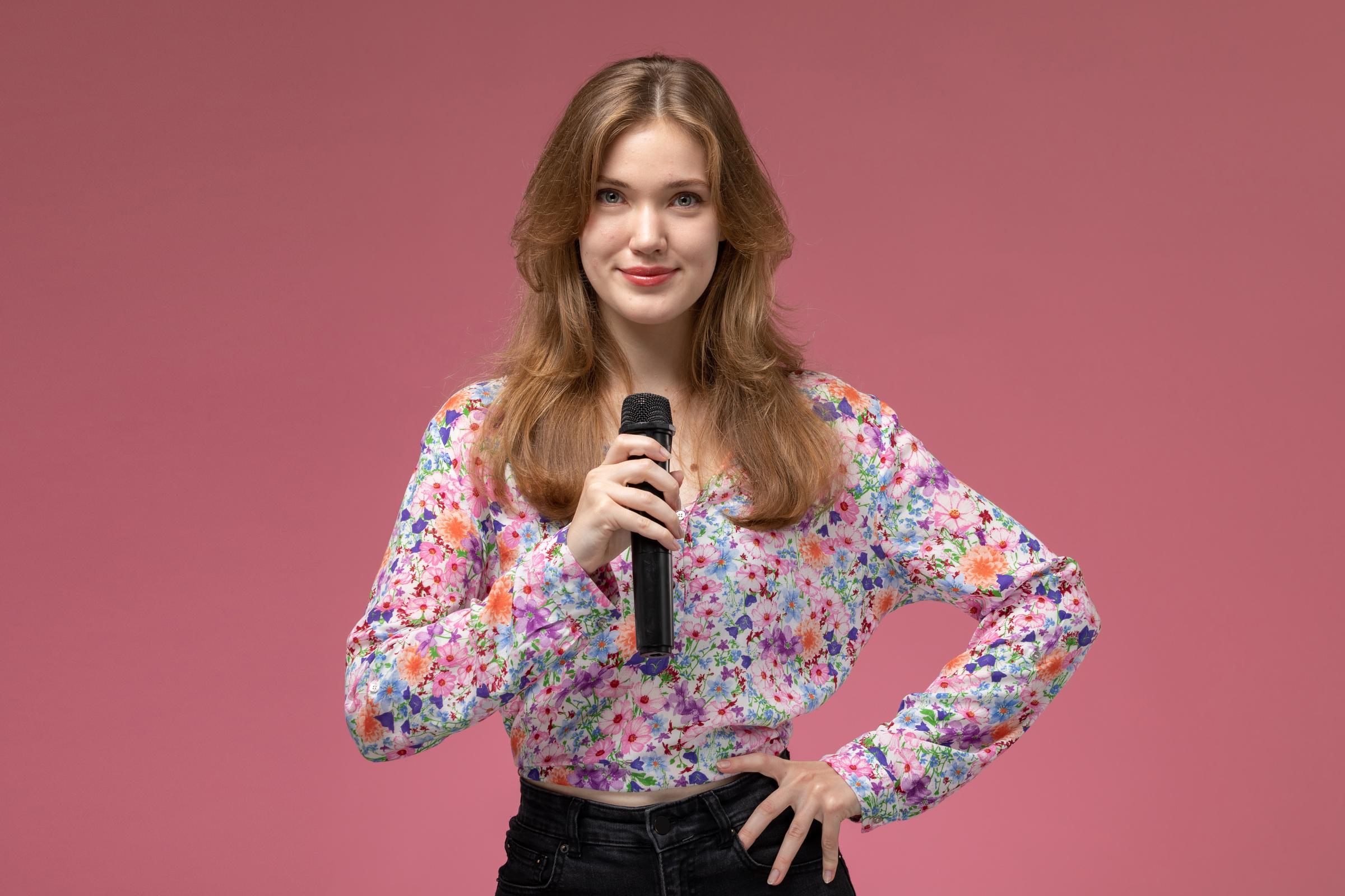 A woman holding a microphone | Source: Freepik