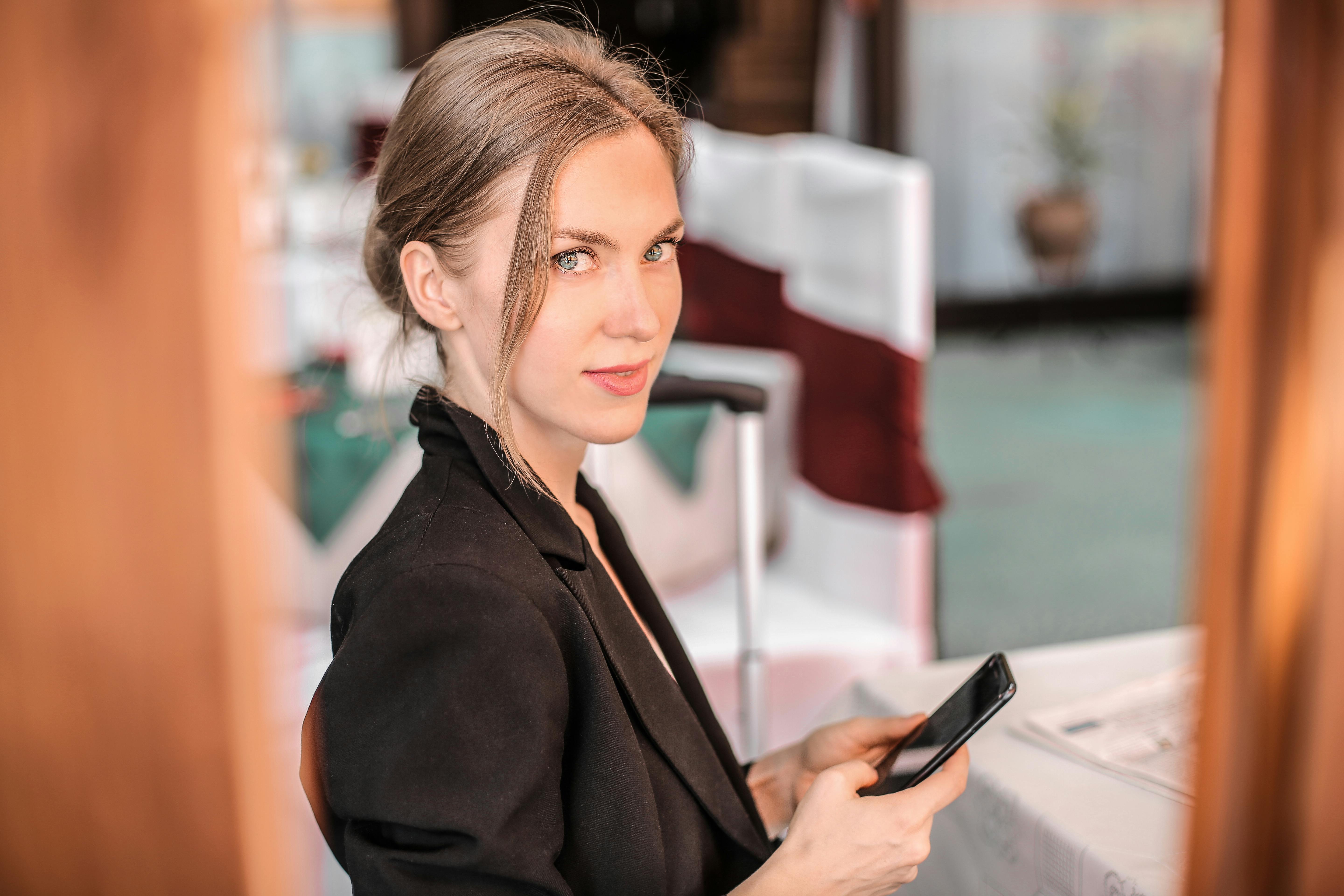 A woman holding her phone | Source: Pexels