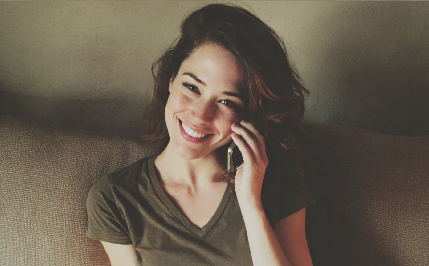 A smiling woman talking on the phone | Source: Midjourney