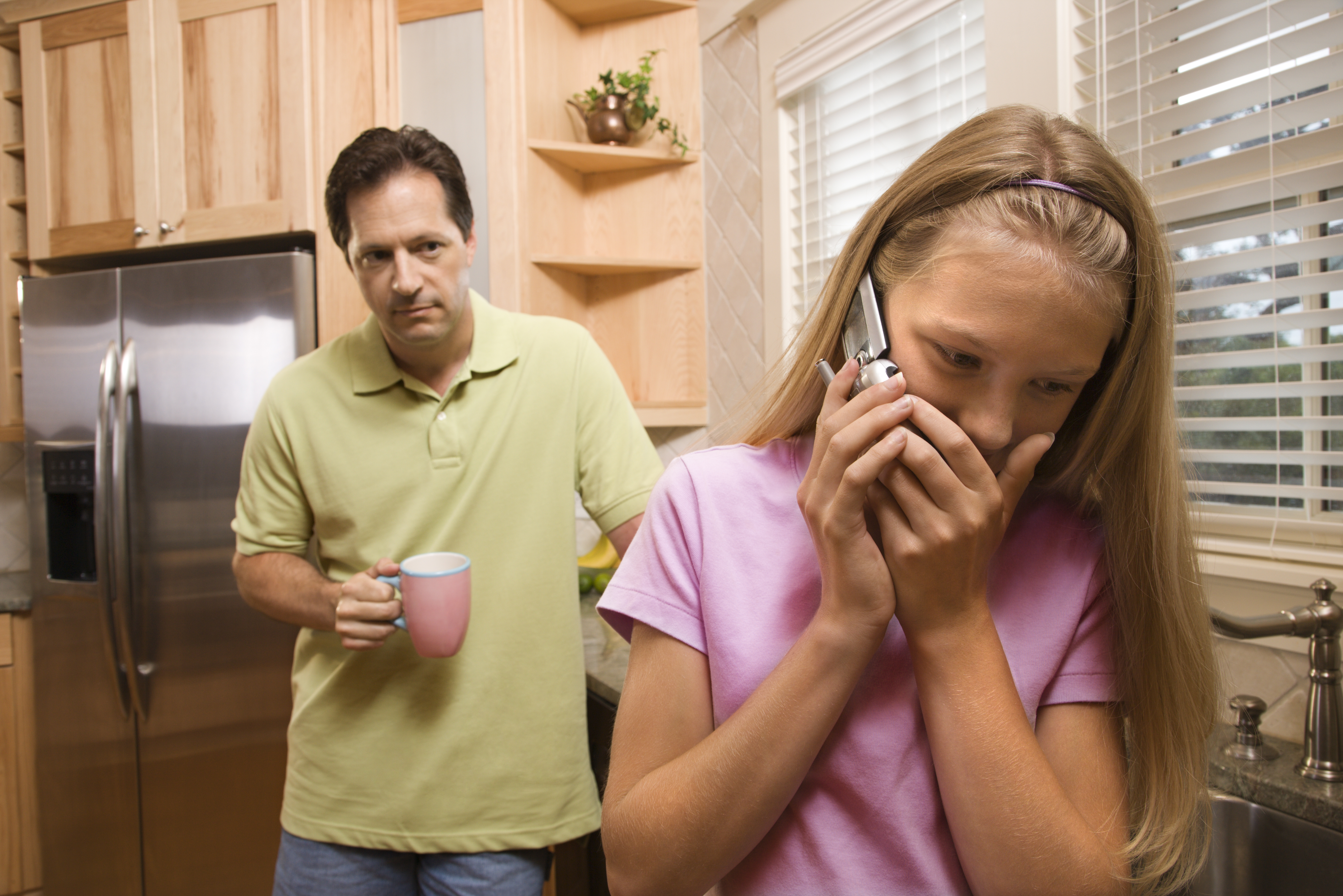 A man watching a young girl talk on the phone | Source: Shutterstock