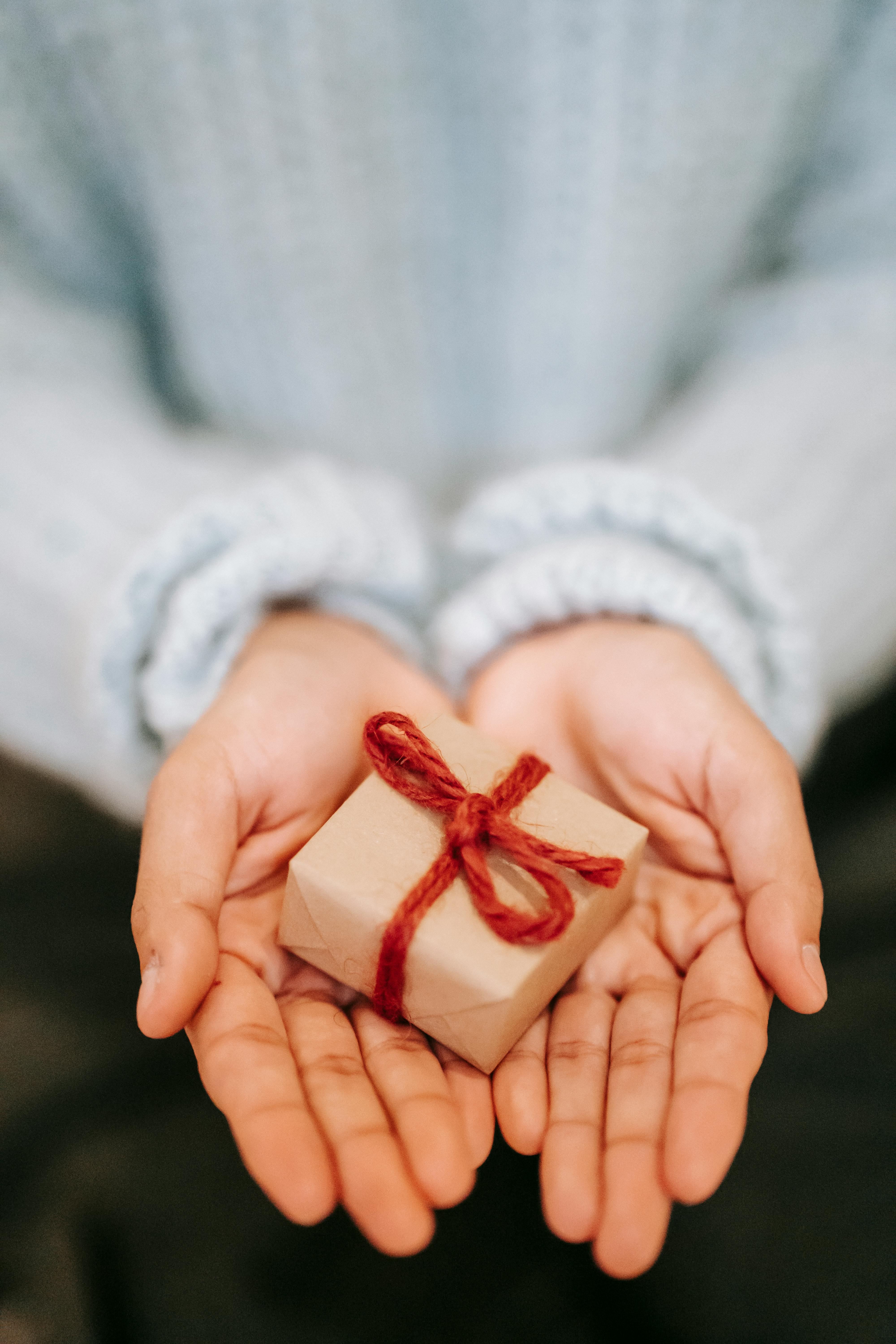 Una mujer sosteniendo una pequeña caja envuelta | Fuente: Pexels