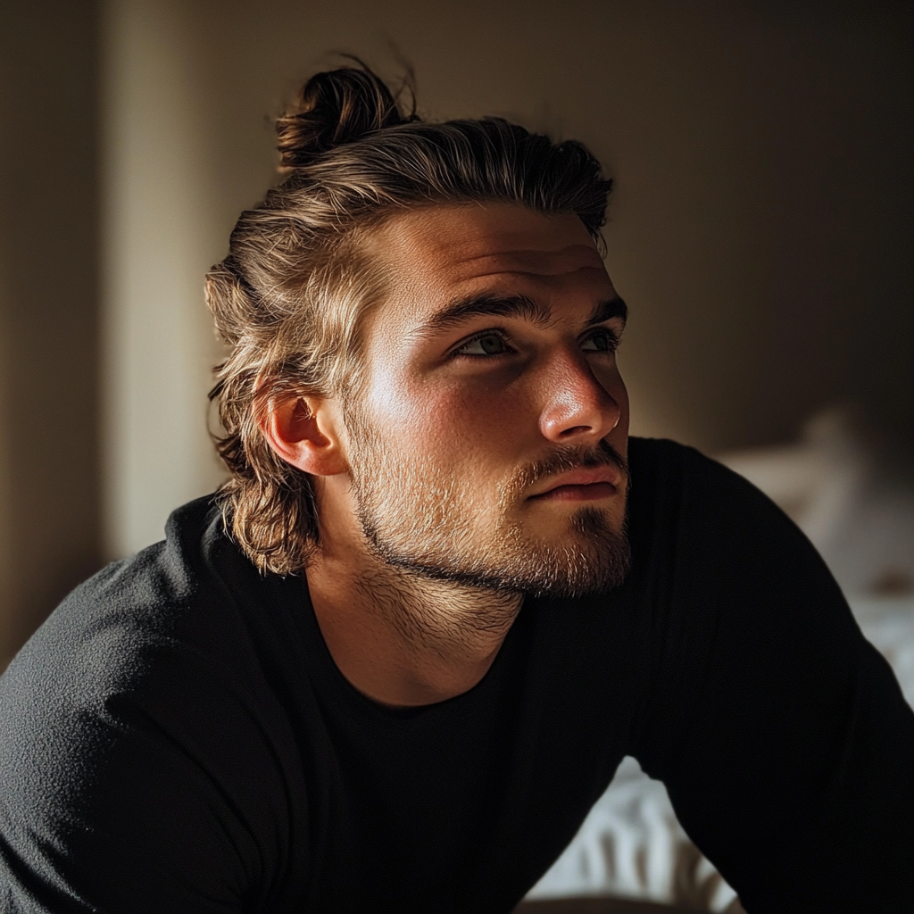 A man sitting on a bed and looking thoughtful | Source: Midjourney