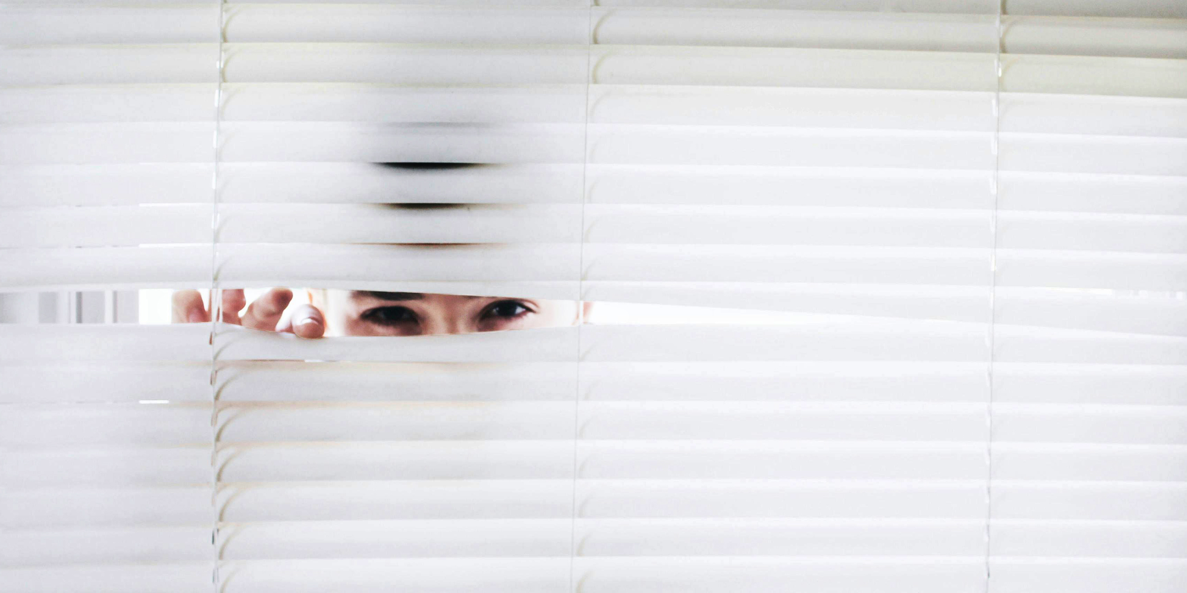 A man peeping through window blinds | Source: Pexels