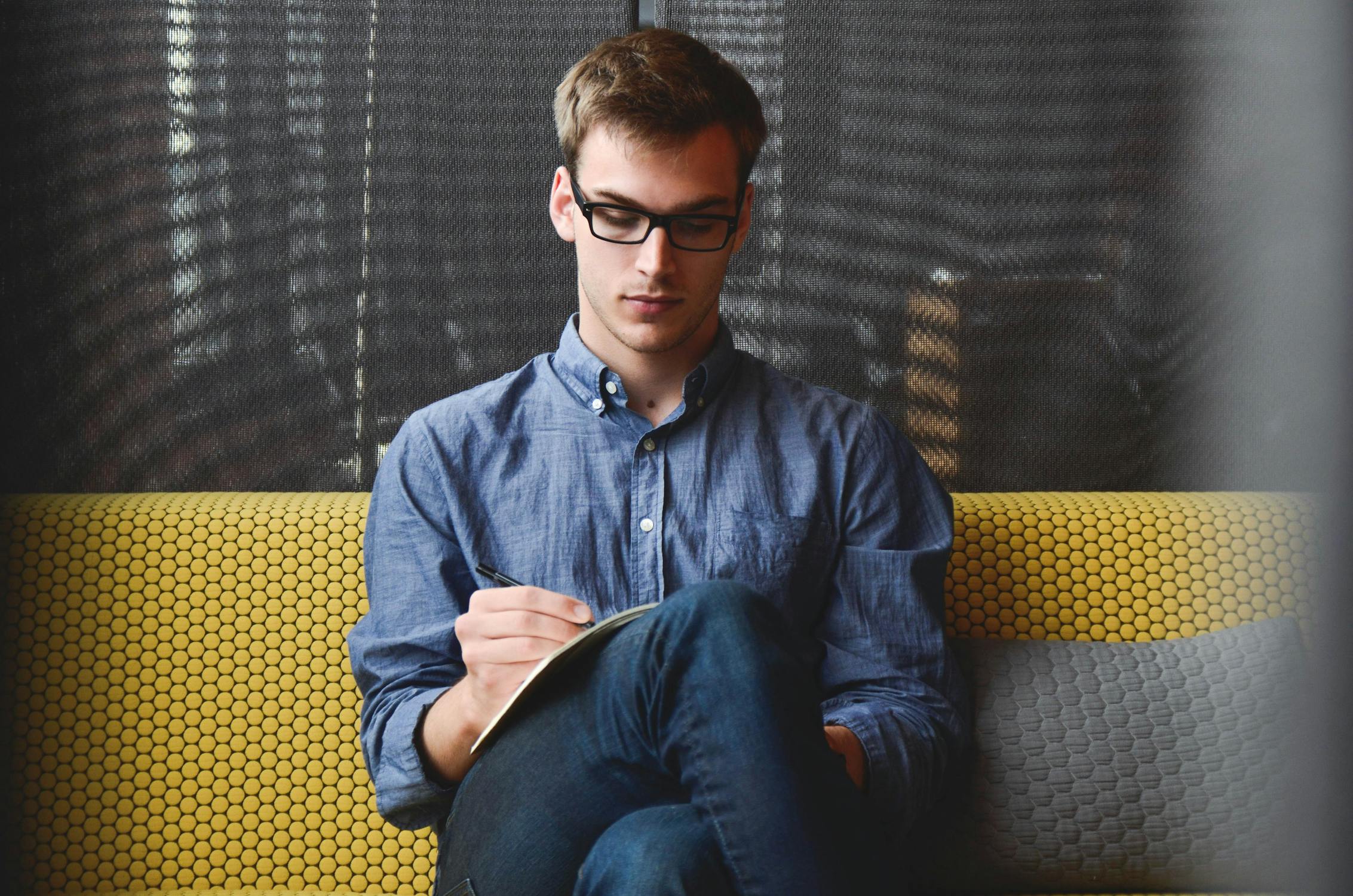 A young man writing | Source: Pexels