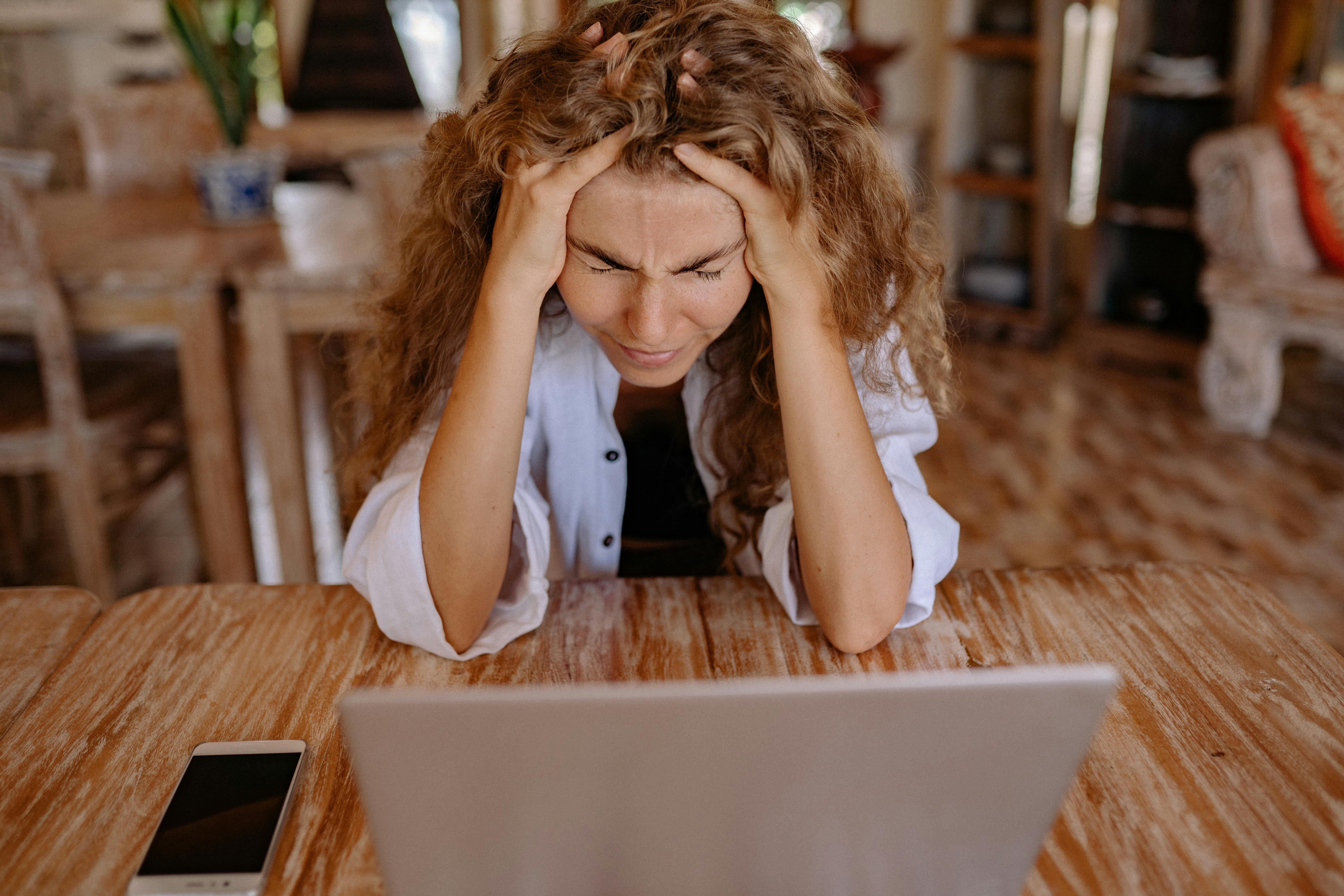 A stressed-out woman with a laptop in front of her | Source: Pexels