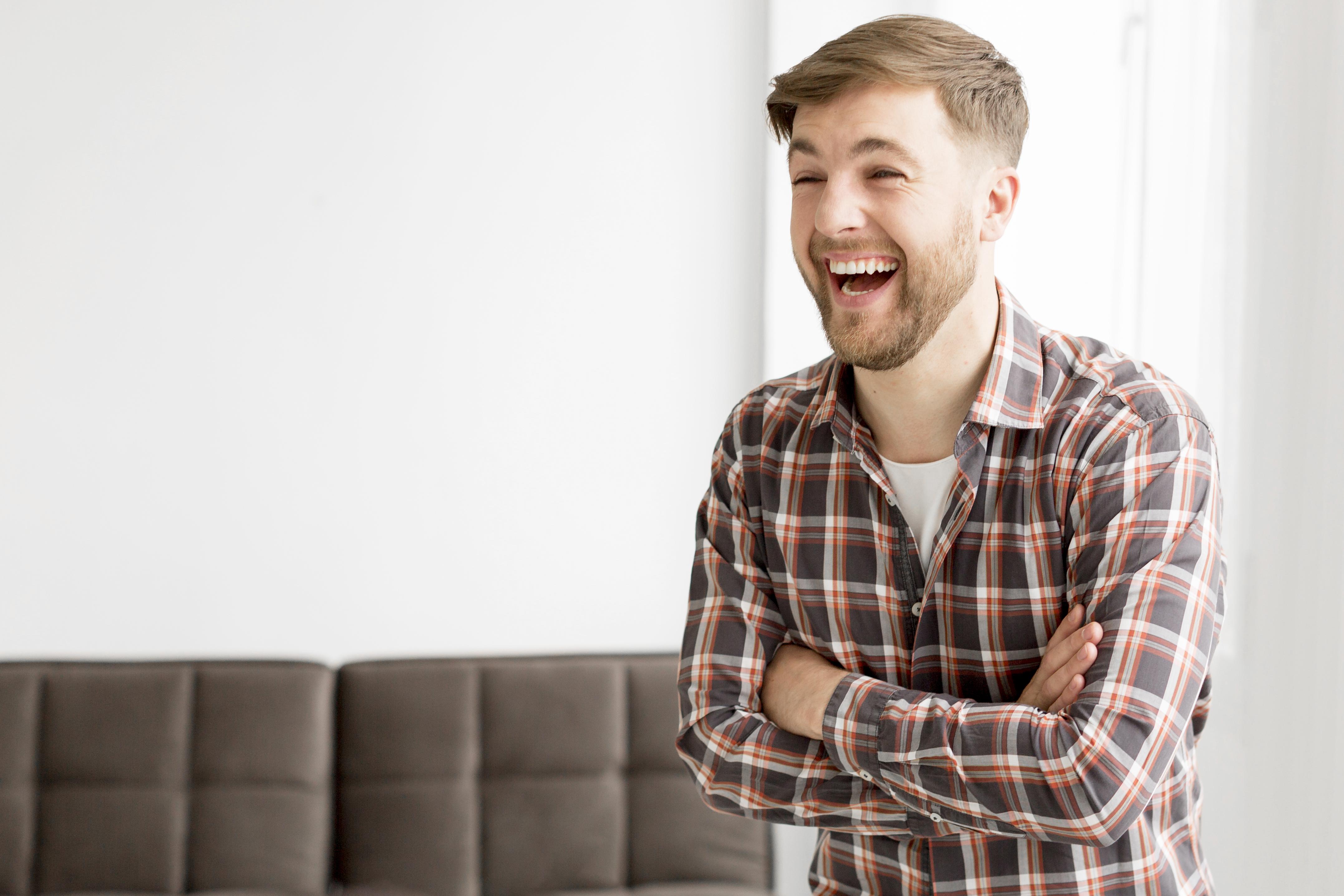 A man laughing with his arms crossed | Source: Freepik