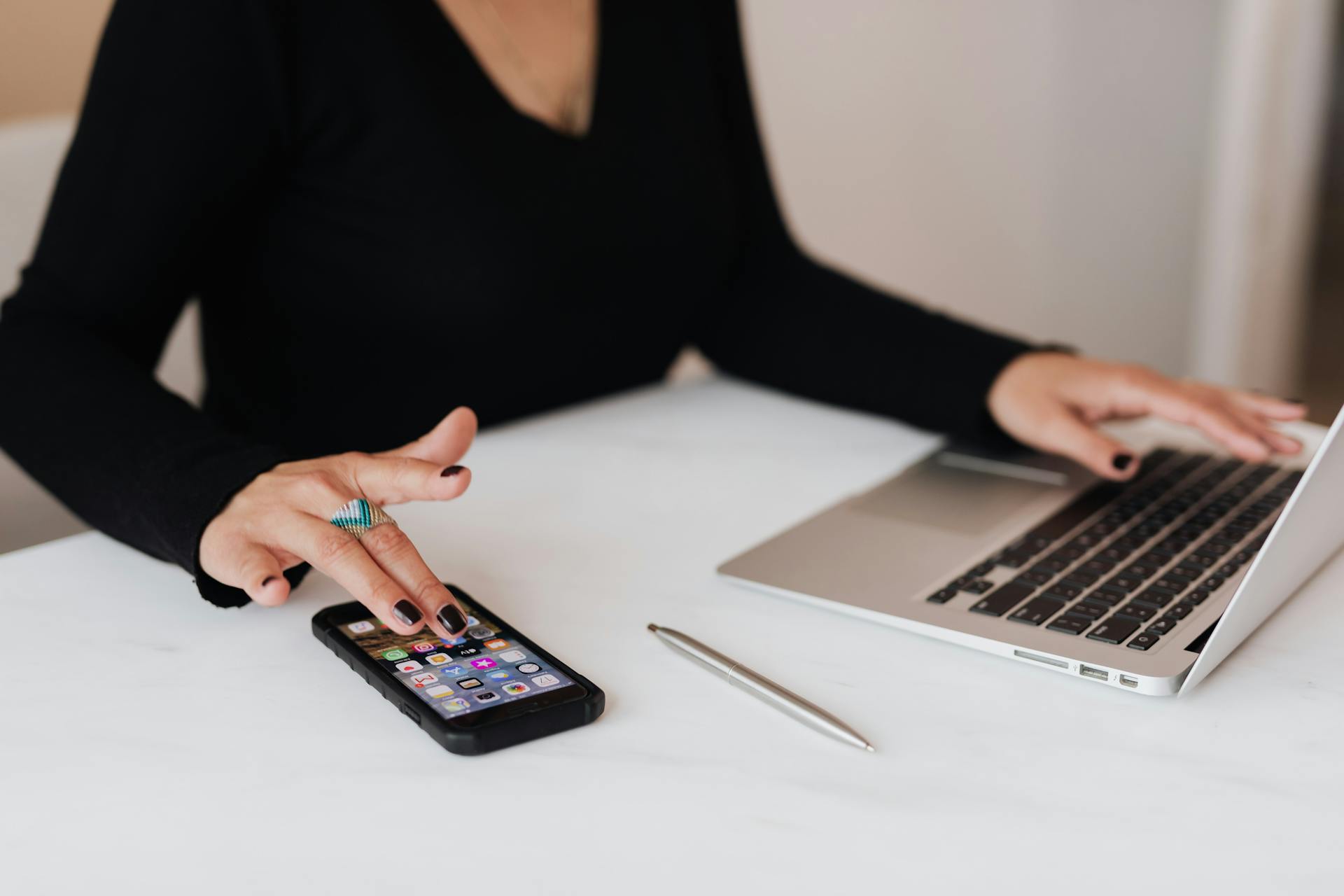 Une femme utilisant simultanément son ordinateur portable et son téléphone | Source : Pexels