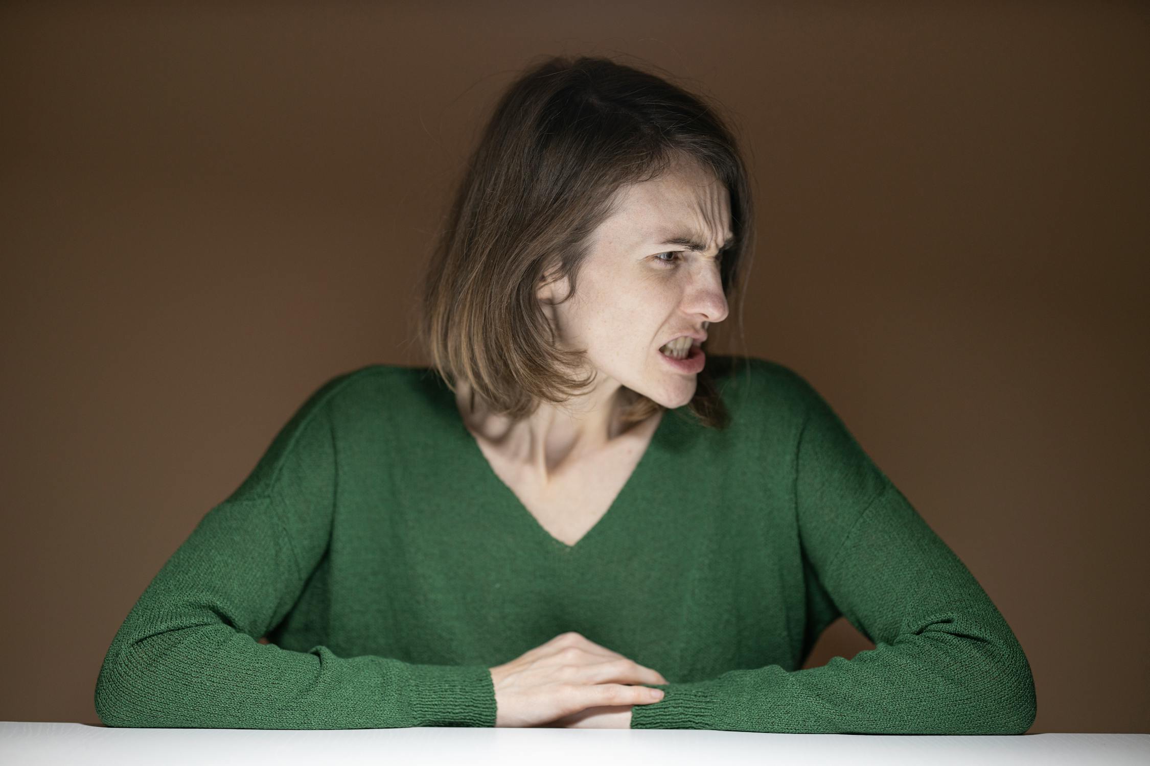 An angry woman in a green sweater | Source: Pexels