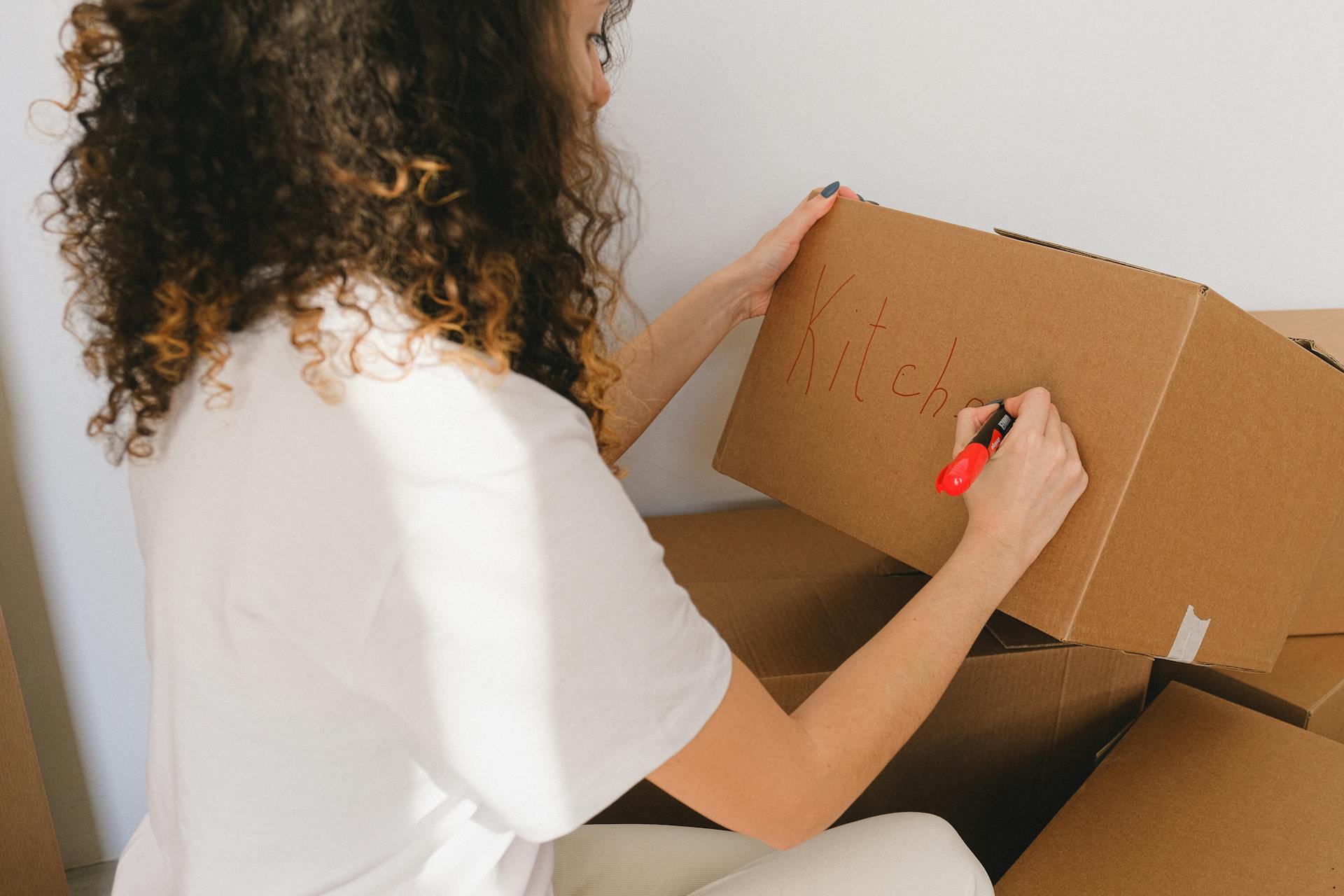 A woman labelling a box | Source: Pexels
