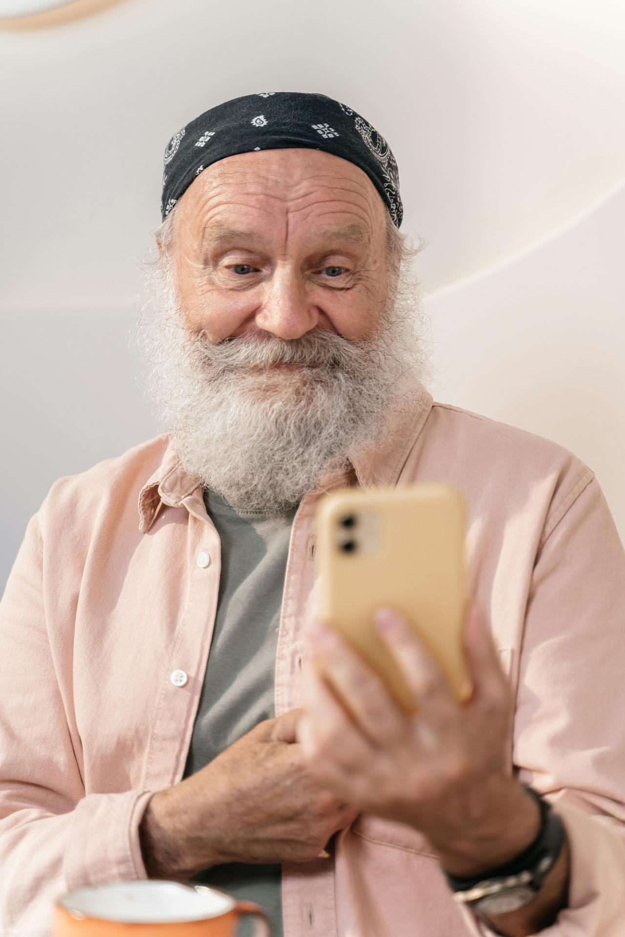 An older man looking at his phone and smiling | Source: Pexels