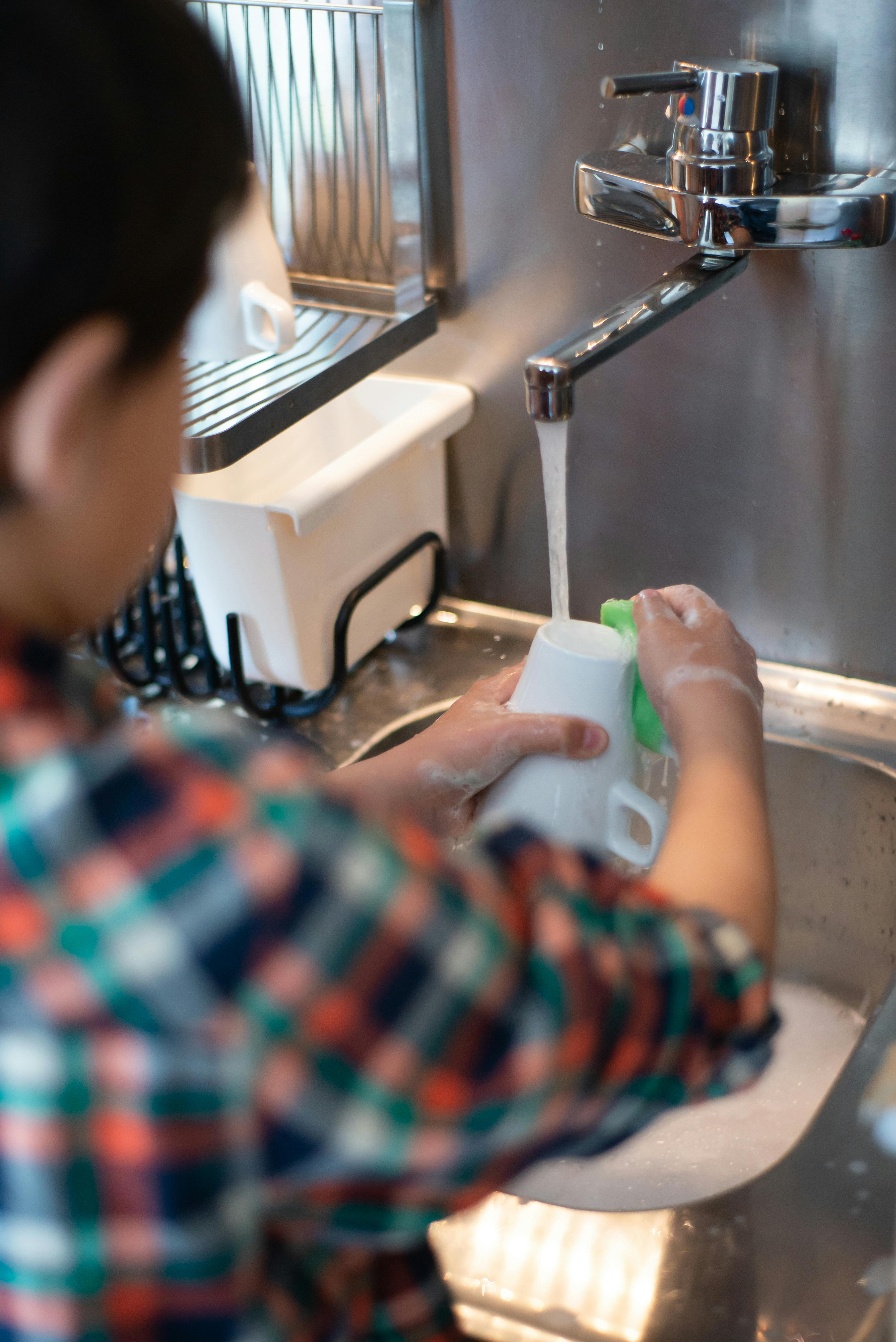 Kid washing a cup | Source: Pexels