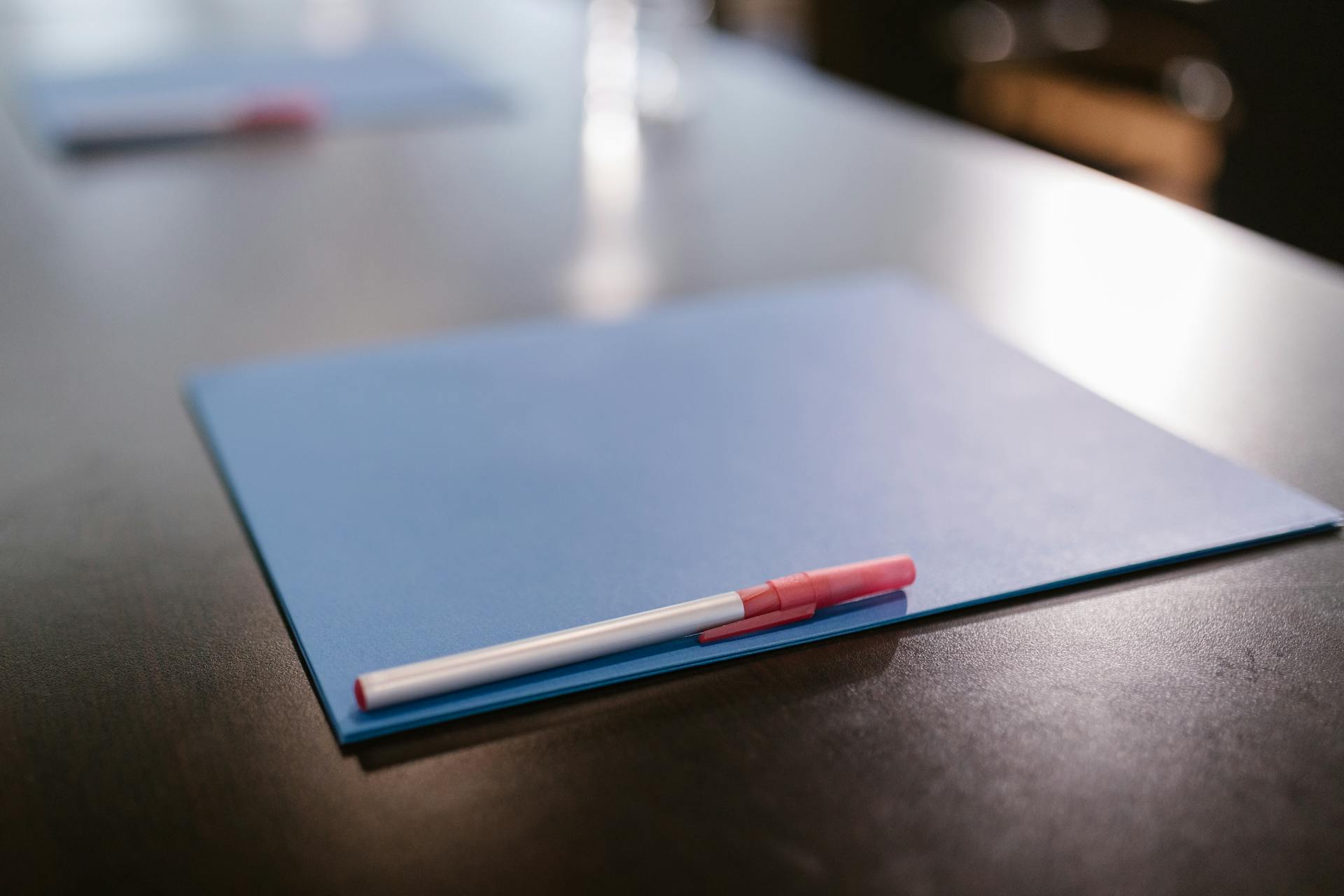 A pen on top of a blue folder on a table | Source: Pexels