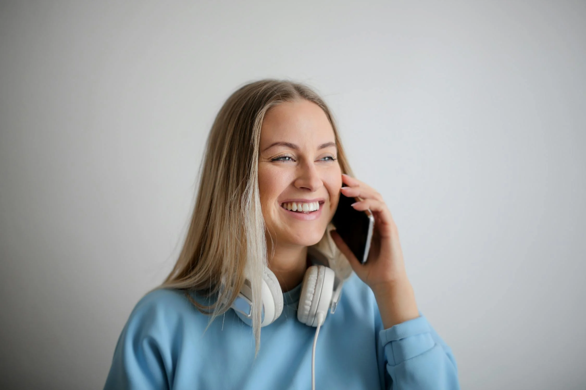 Una mujer sonriente hablando por teléfono | Fuente: Pexels