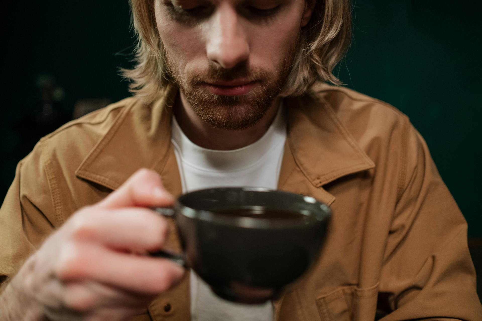 A relieved man holding a cup of coffee | Source: Pexels