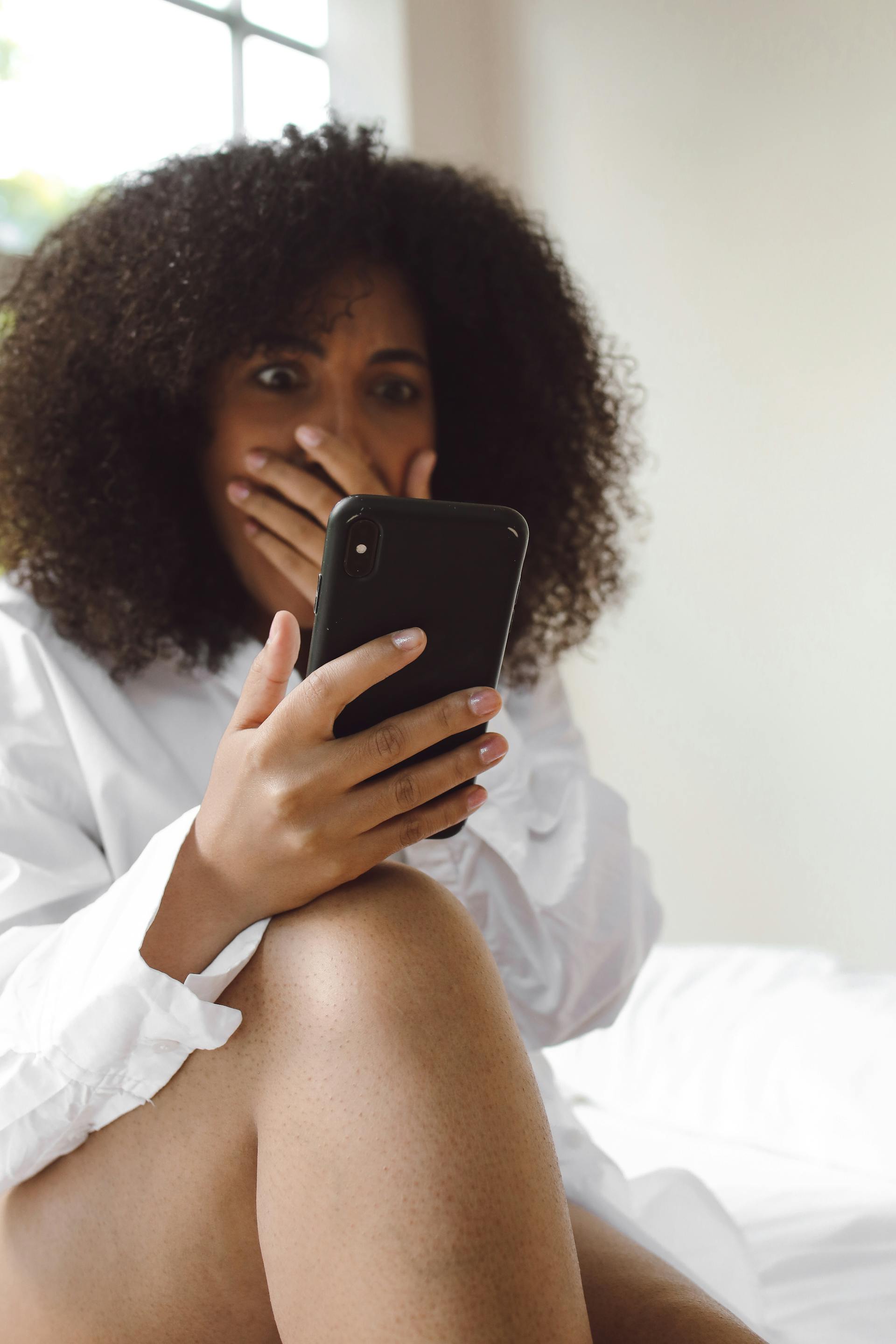A shocked woman looking at a phone | Source: Pexels