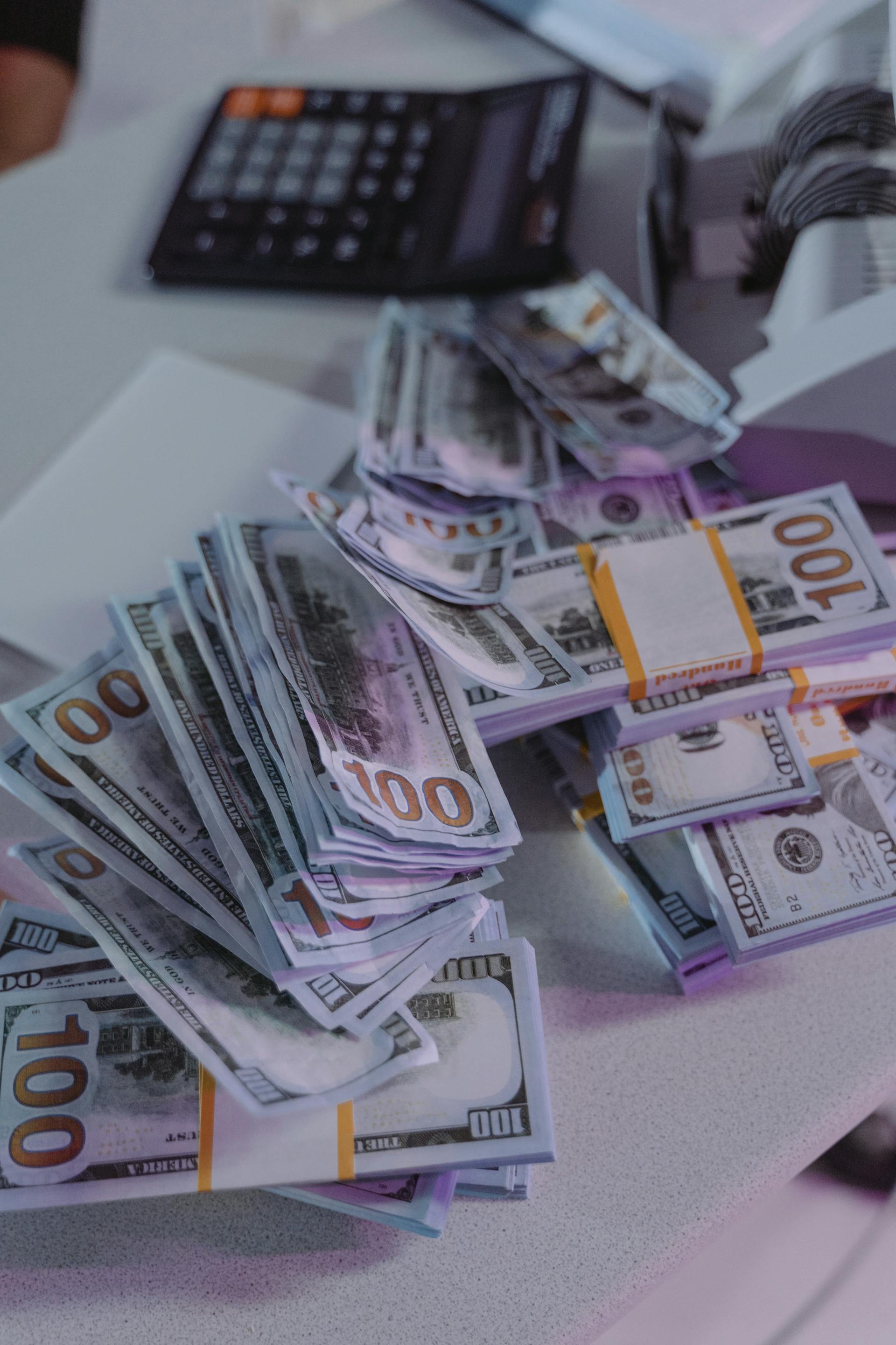 Bundles of 100-dollar bills lying on a table | Source: Pexels