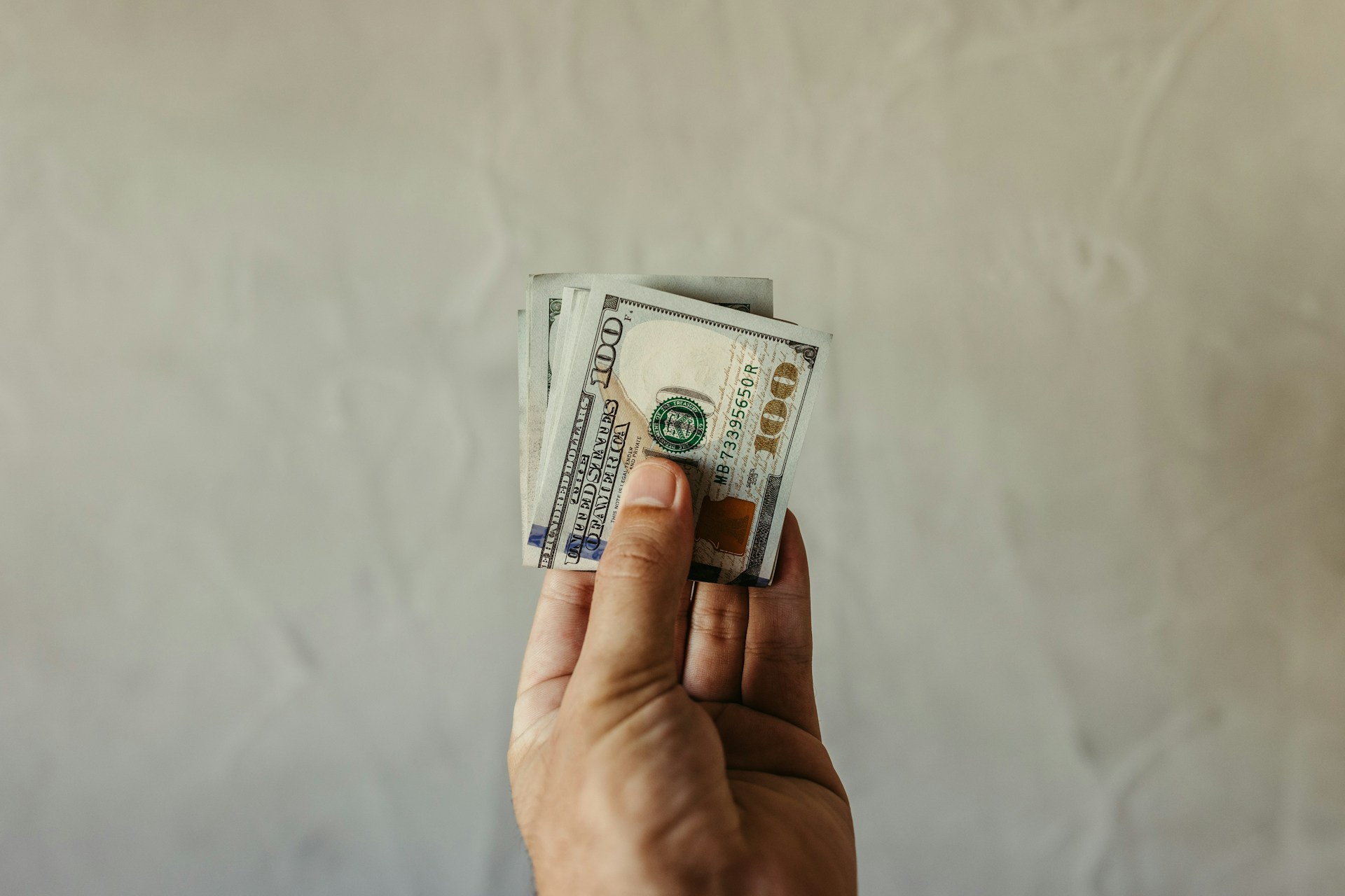 A man holding dollar bills | Source: Unsplash
