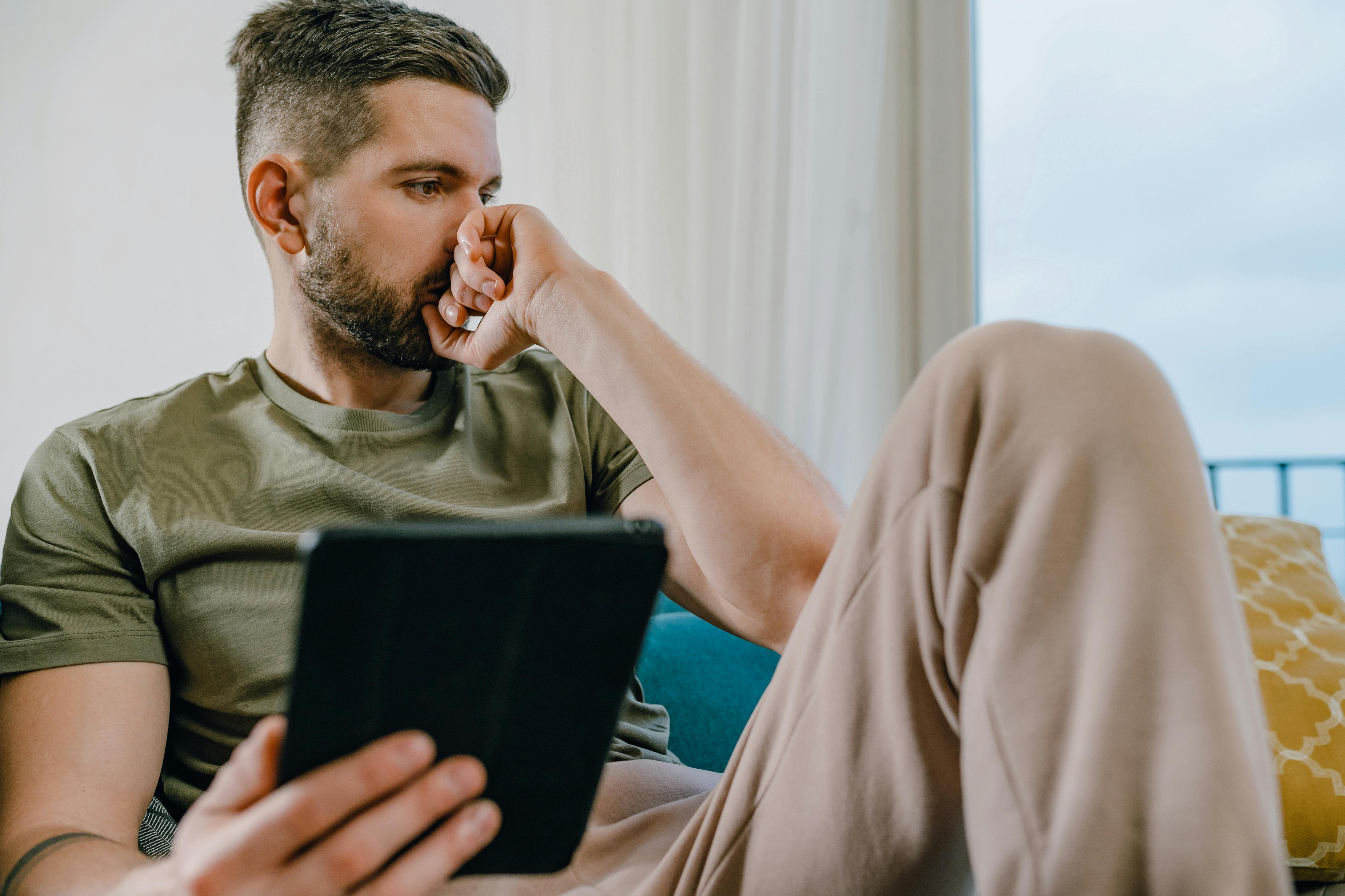 A man in deep thought holding a tablet | Source: Pexels