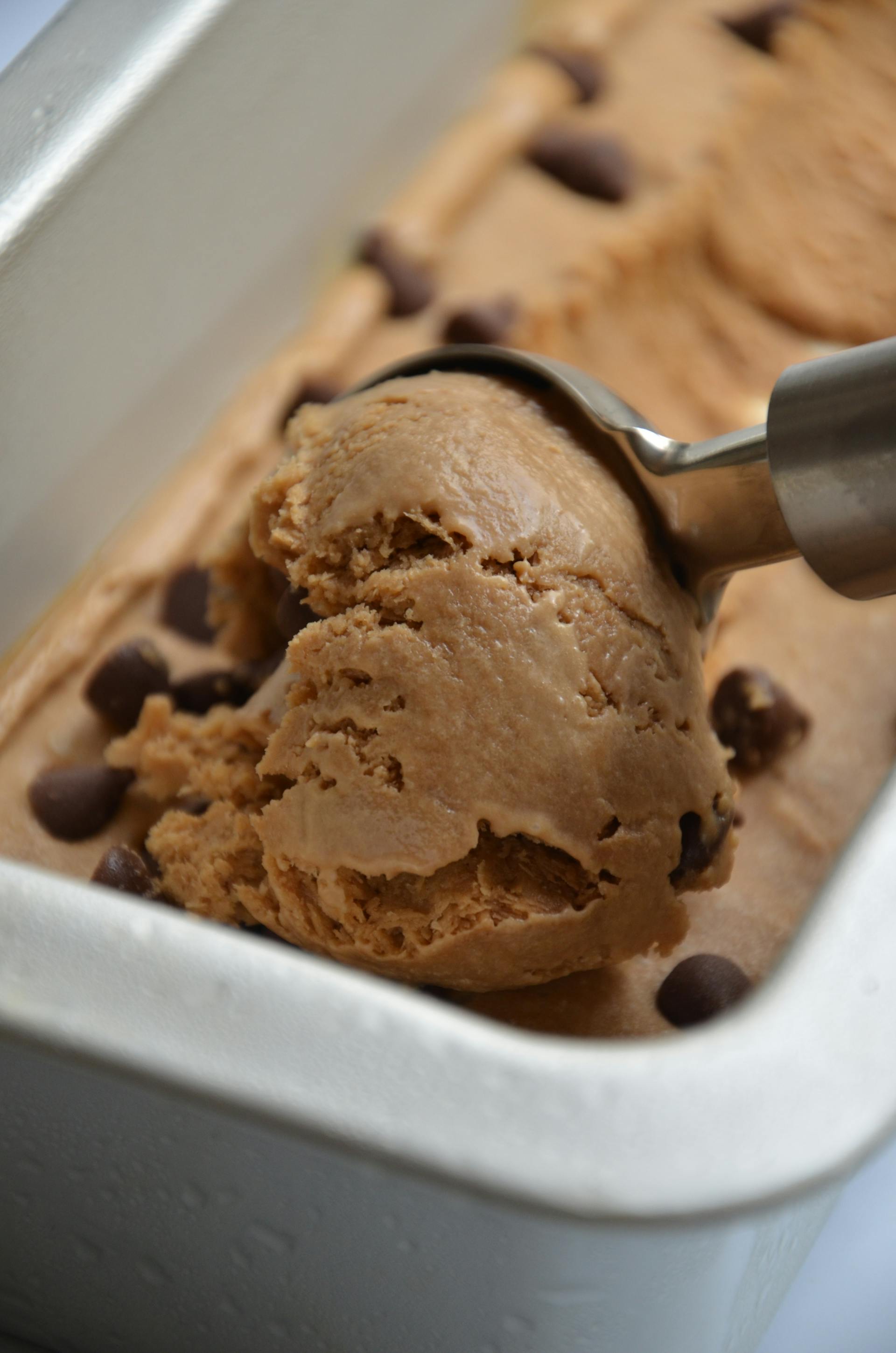 A close-up of a scoop of chocolate chip ice cream being taken out of a container | Source: Pexels
