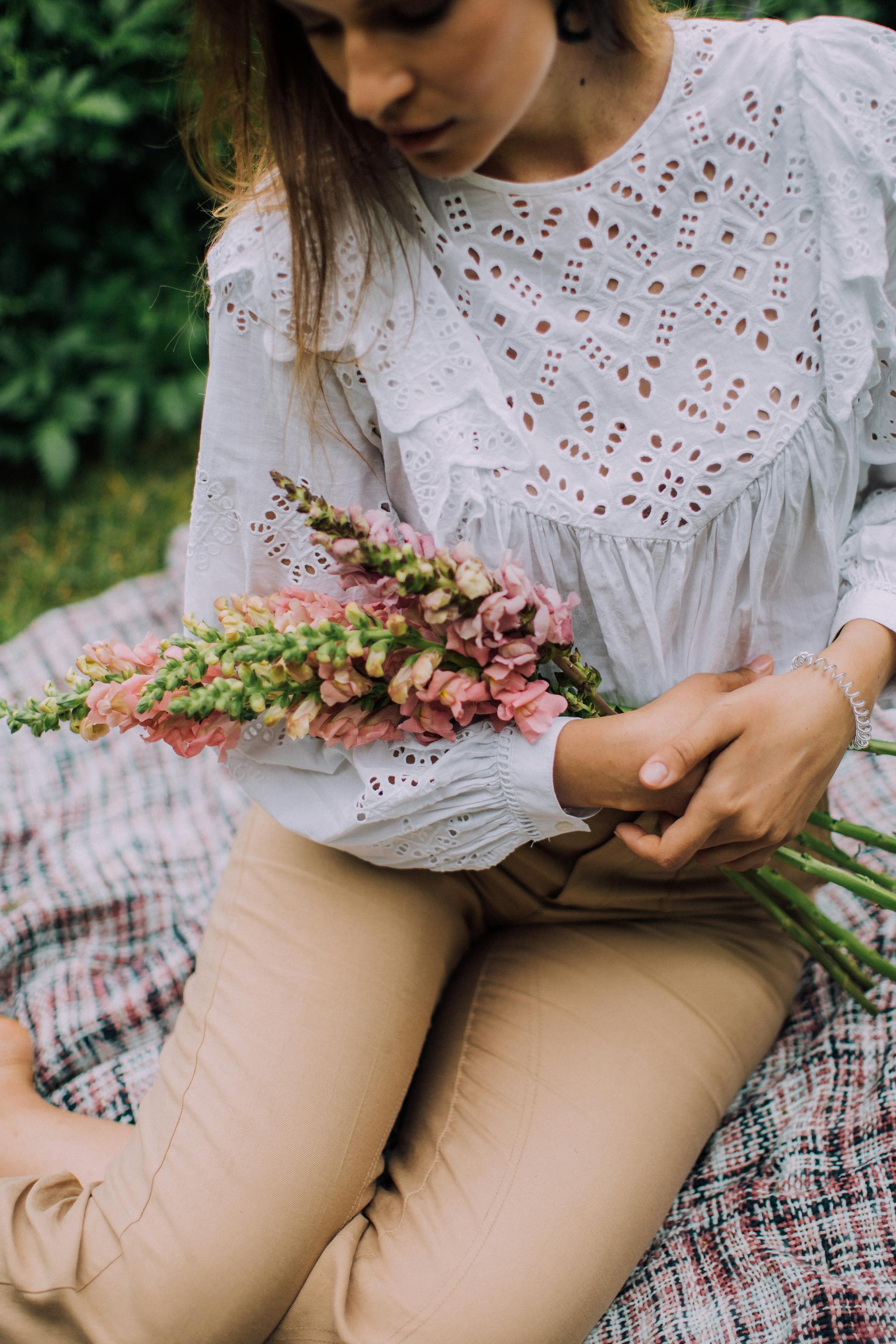 A woman holding flowers | Source: Pexels
