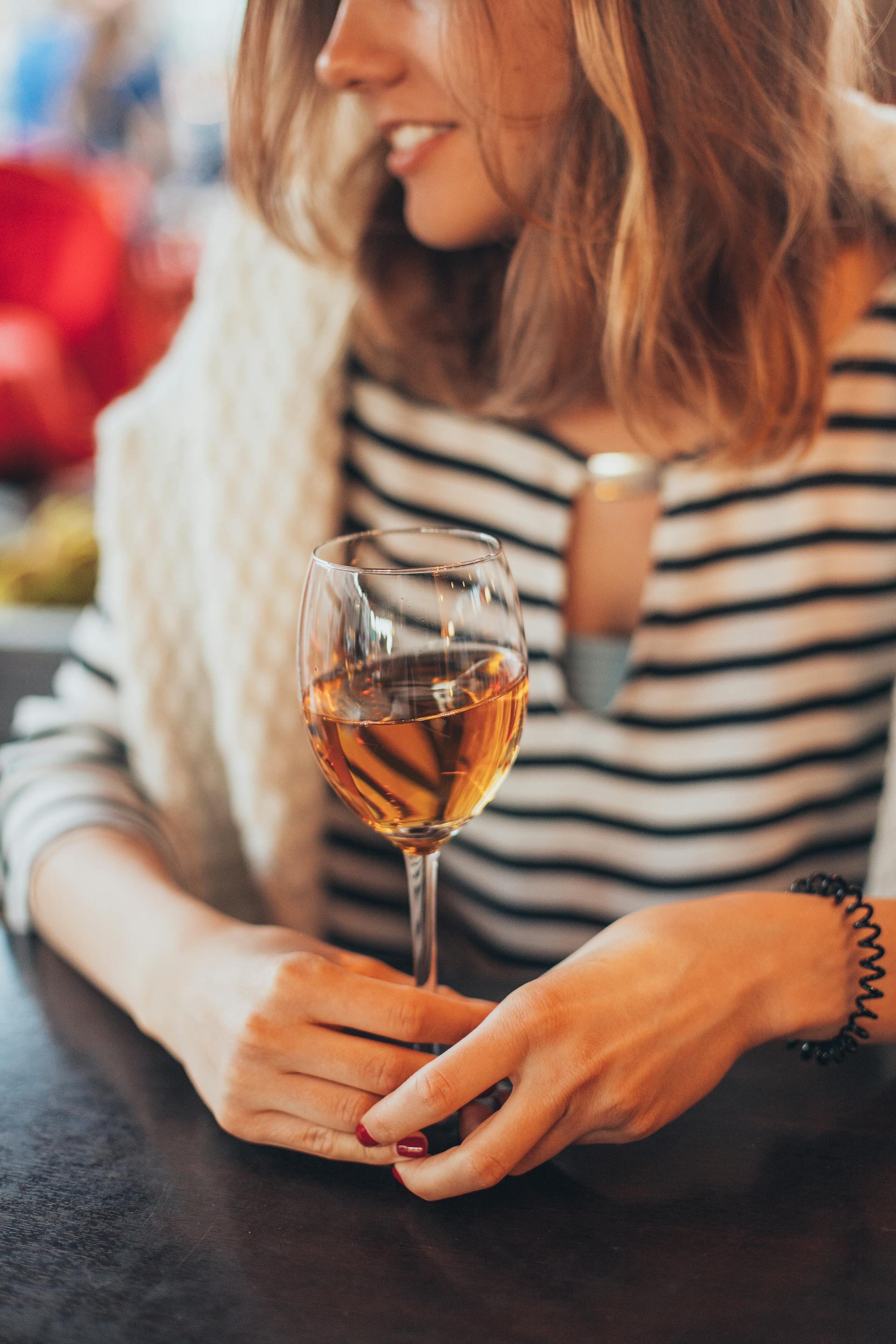 A woman speaking while holding a glass | Source: Pexels