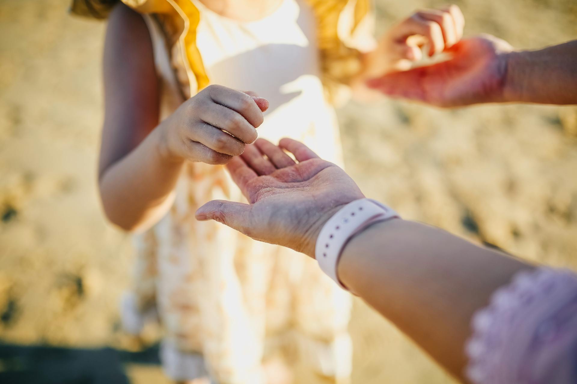 A girl holding her parents' hands | Source: Pexels